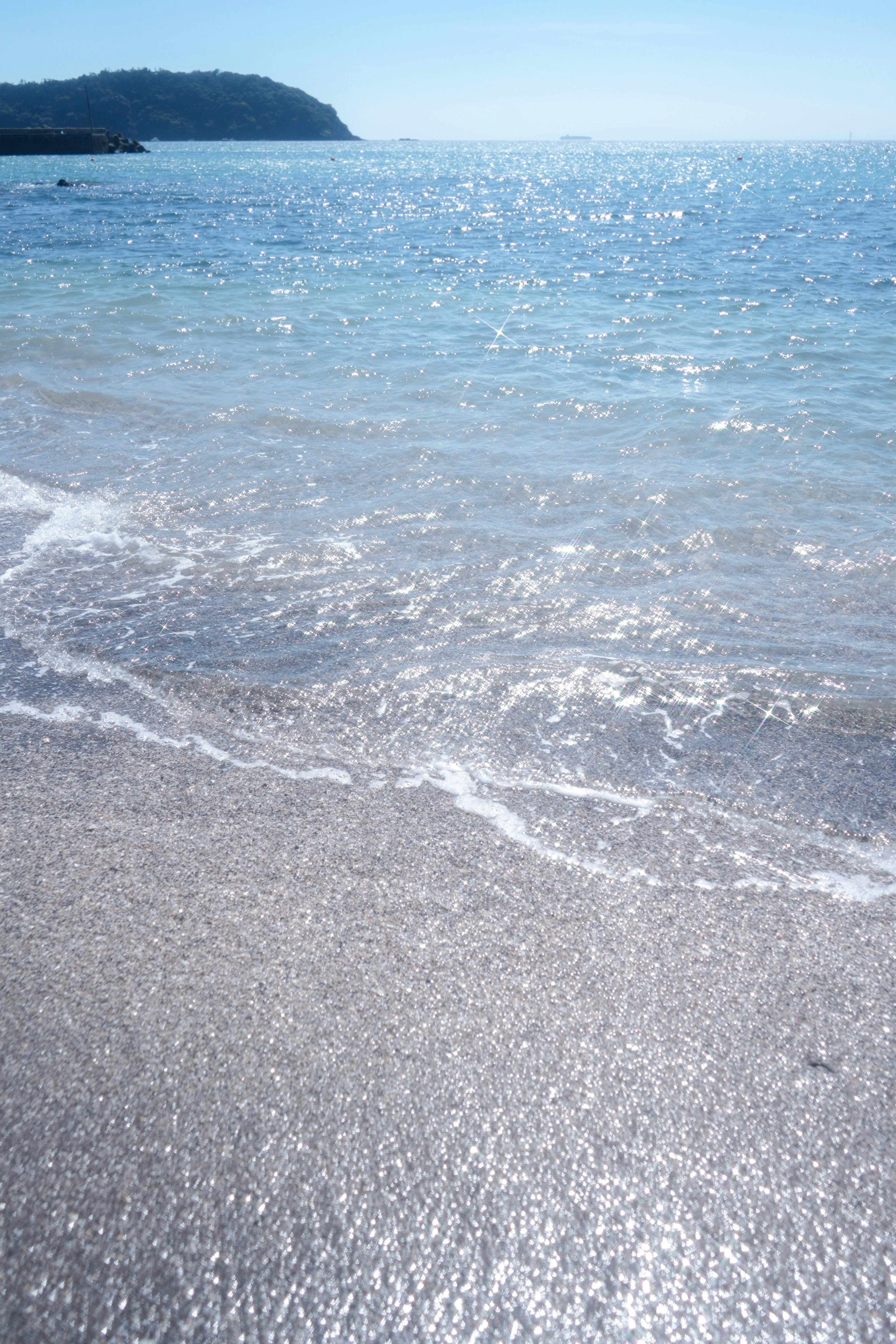 Mer bleue avec des vagues douces qui s'échouent sur le rivage