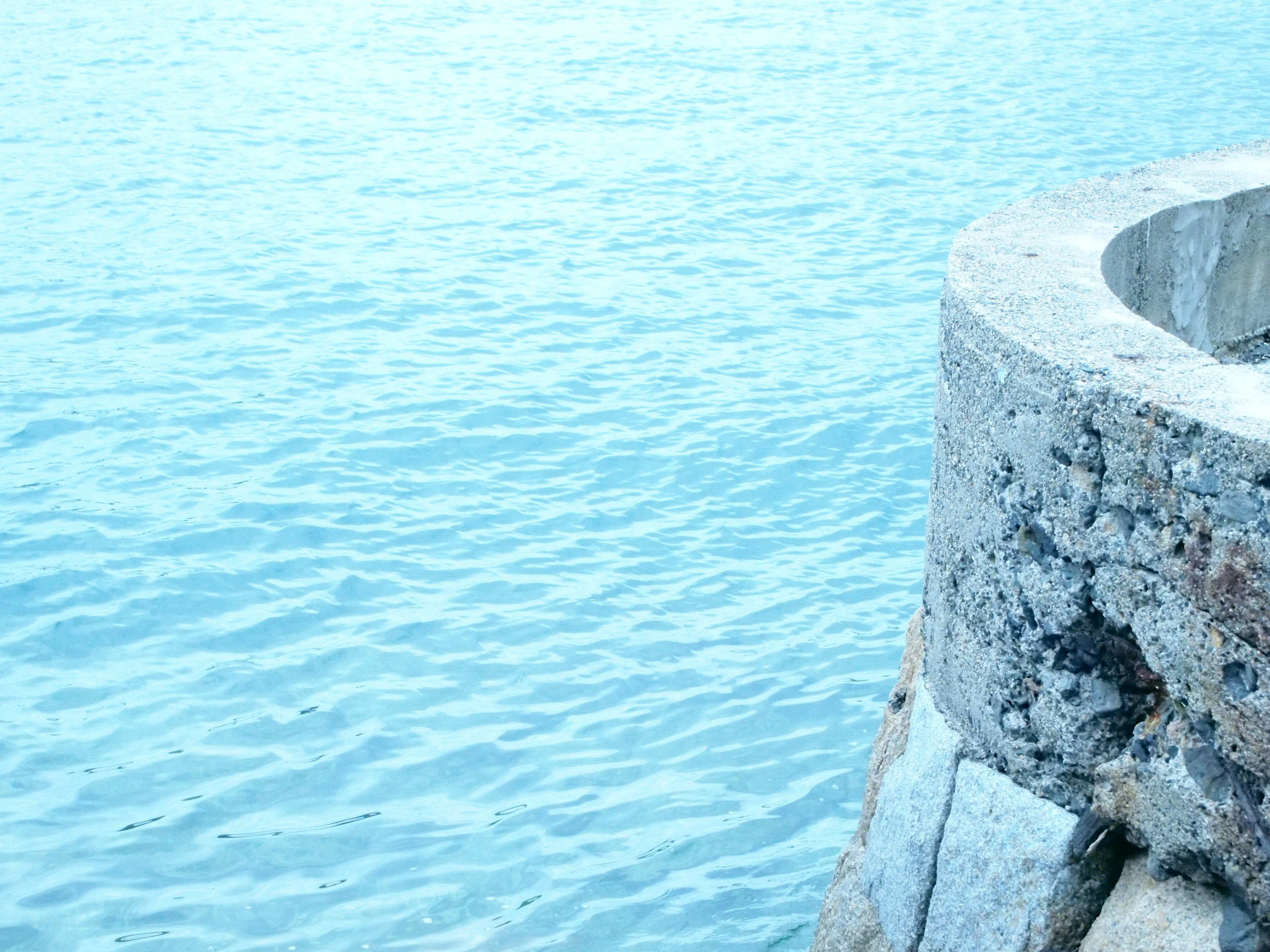 Mer bleue avec une section d'un vieux mur de pierre