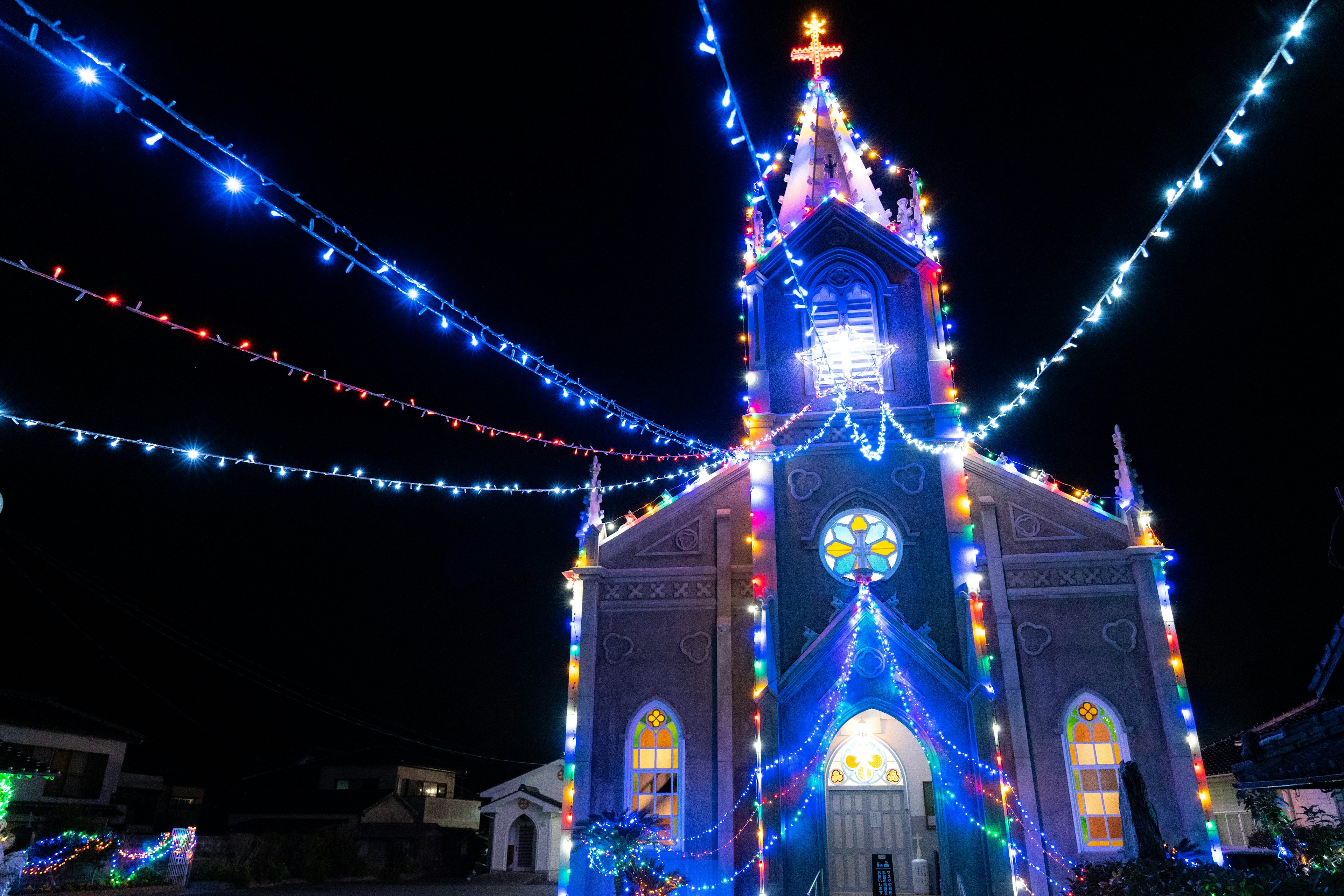 Luces coloridas iluminan la iglesia por la noche con decoraciones azules y festivas