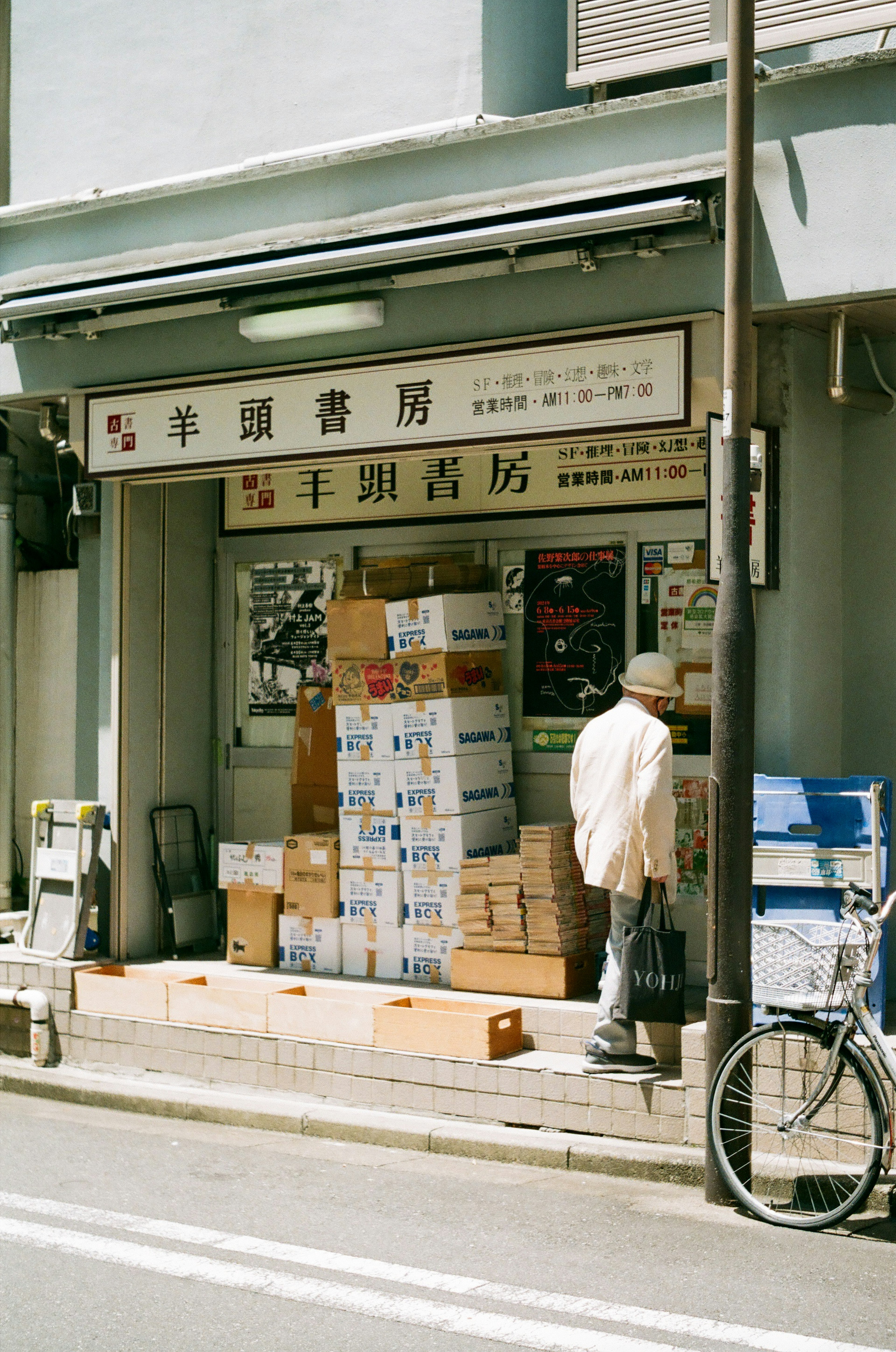 Fachada de una tienda antigua con cajas apiladas y una bicicleta