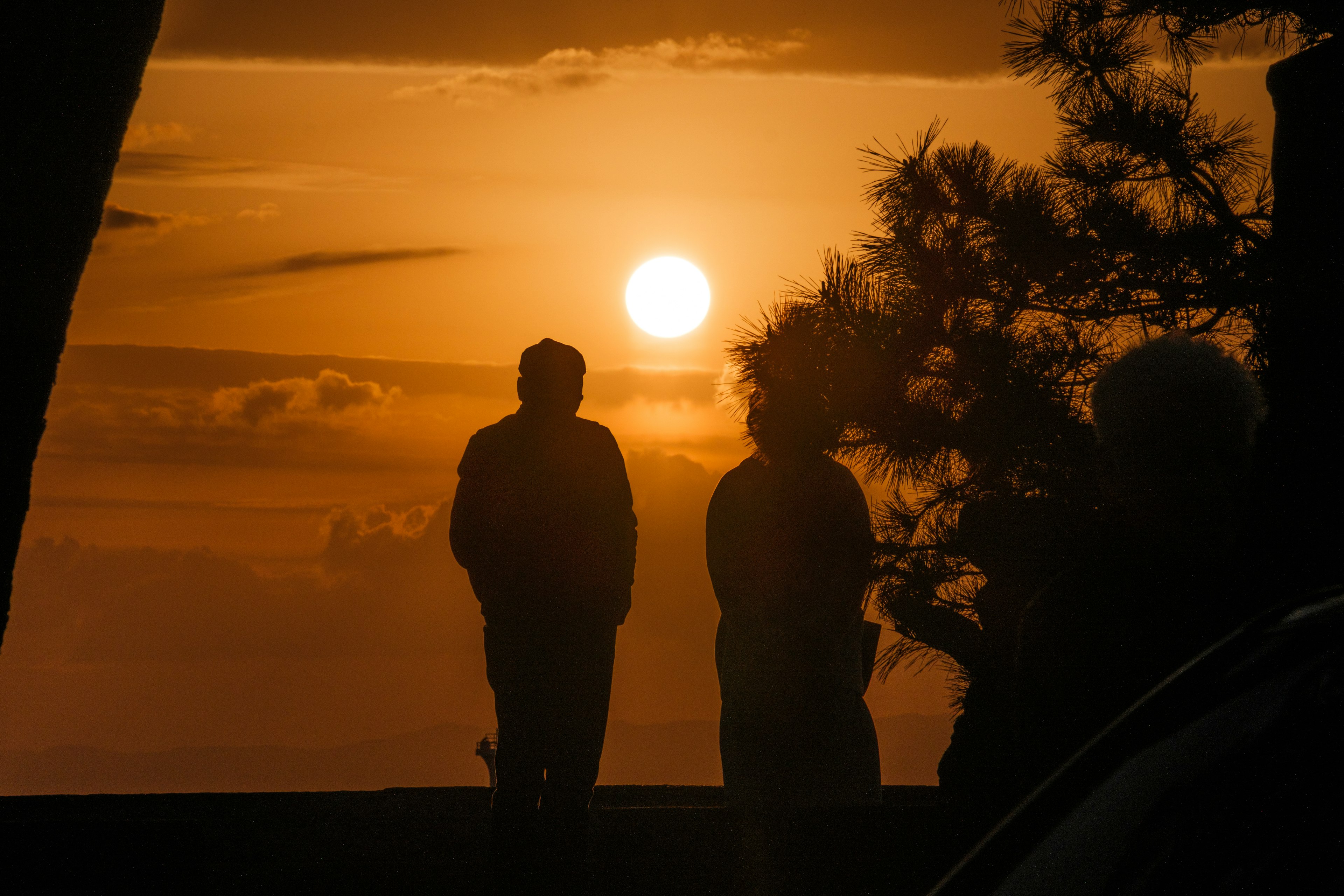 Silhouetten von Menschen vor einem Sonnenuntergang