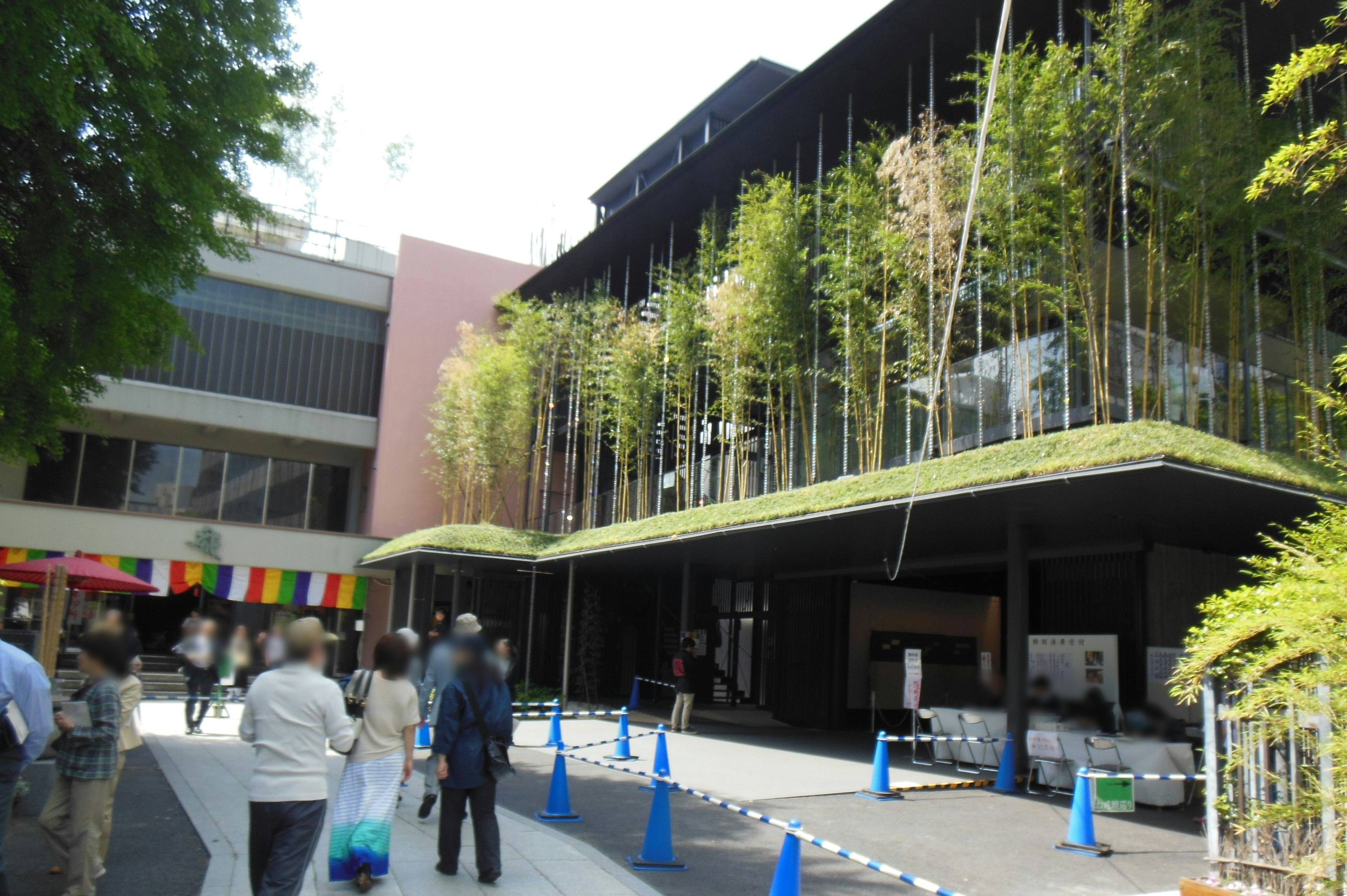 Modern building with bamboo greenery and people walking