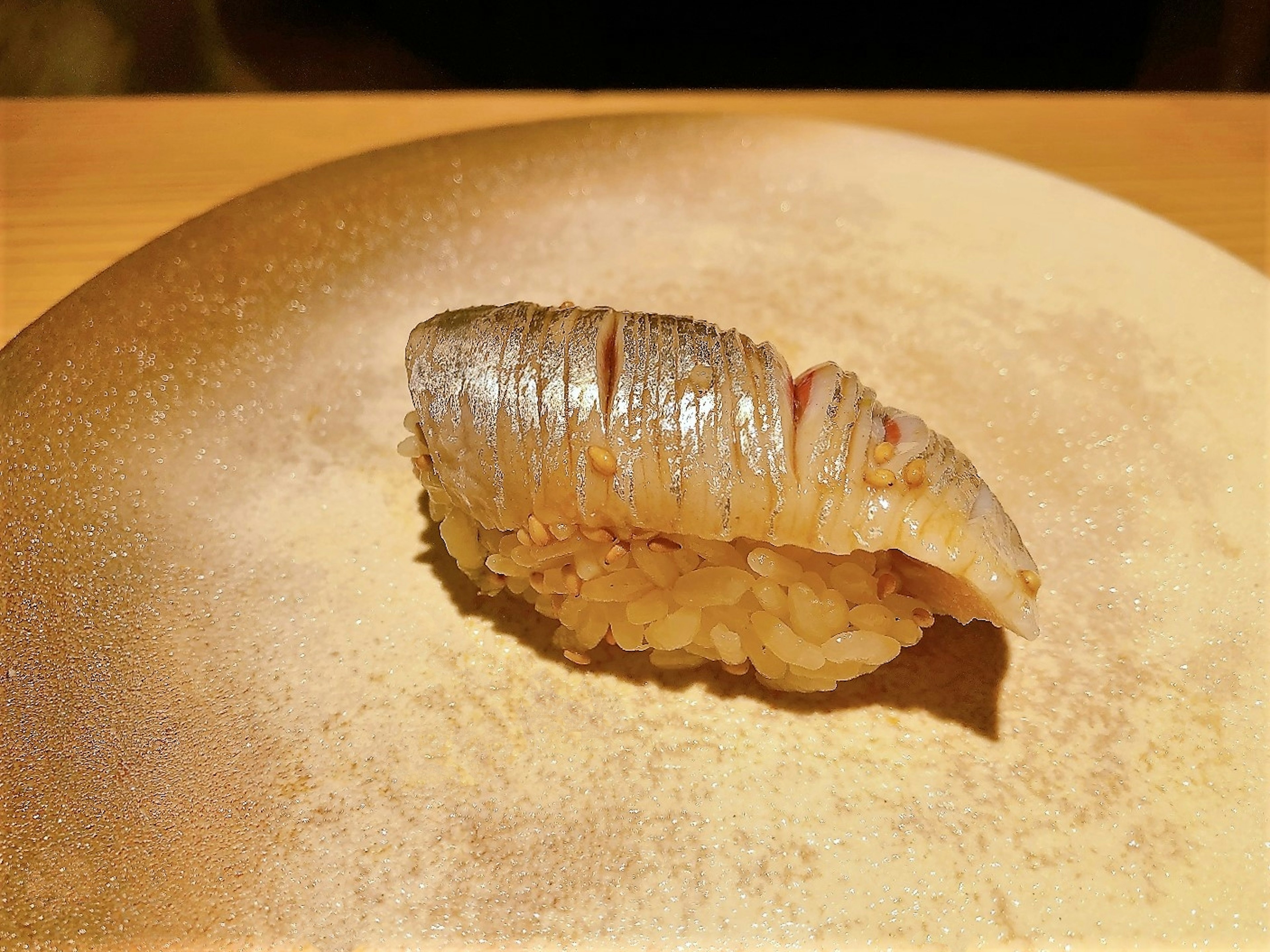 Un trozo de sushi bellamente presentado en un plato dorado