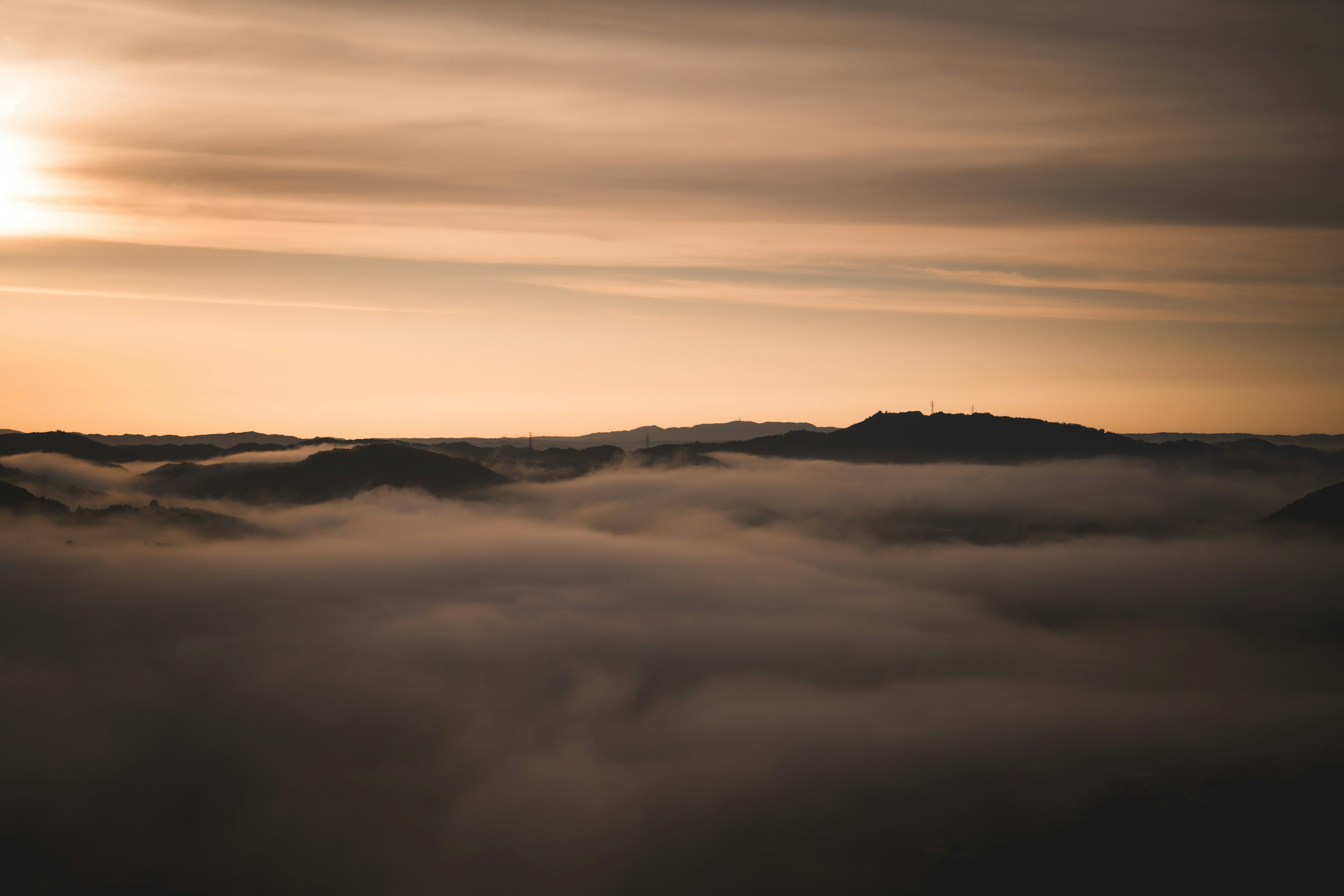 Montagnes enveloppées de brume avec un doux coucher de soleil