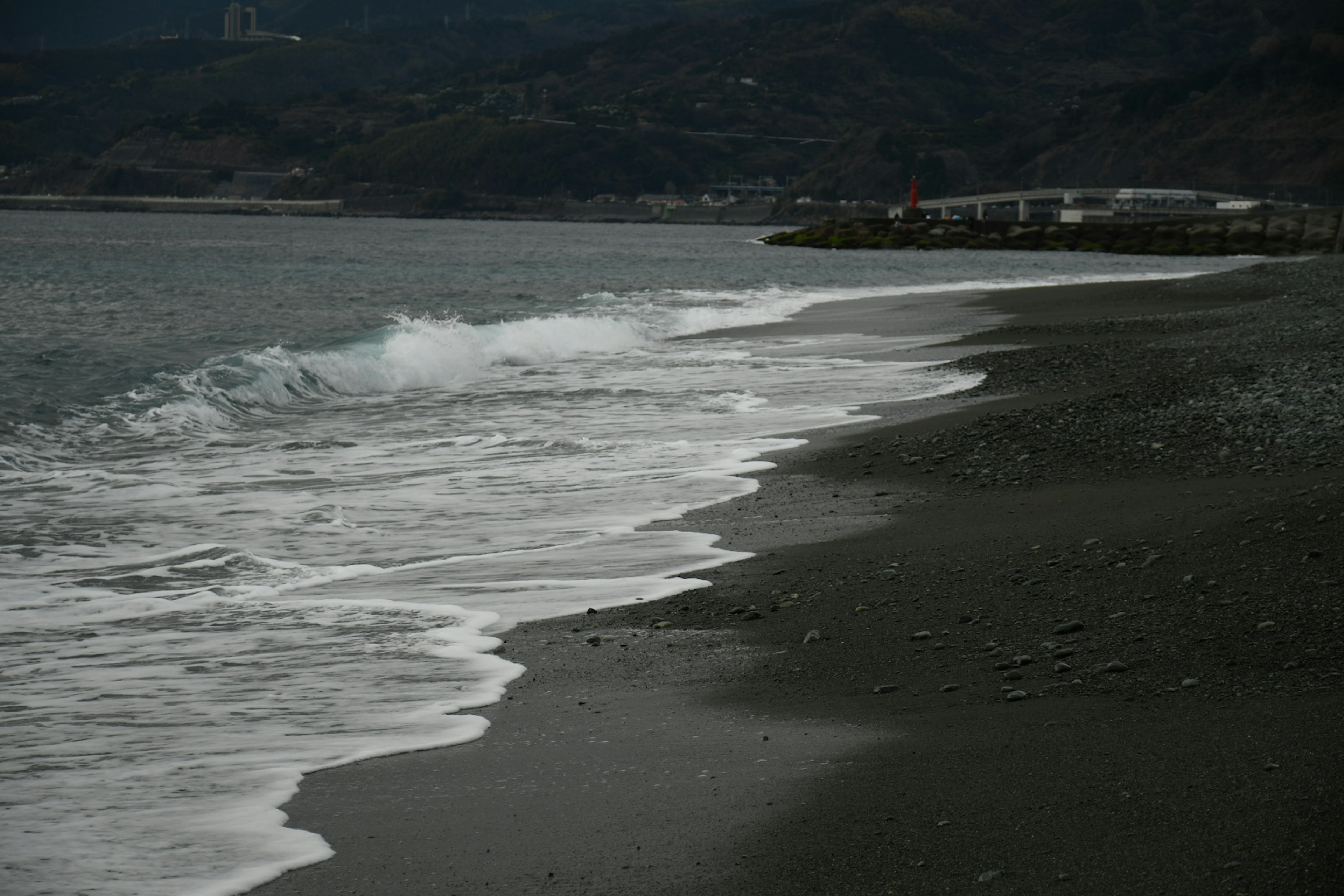 Plage de sable sombre avec des vagues