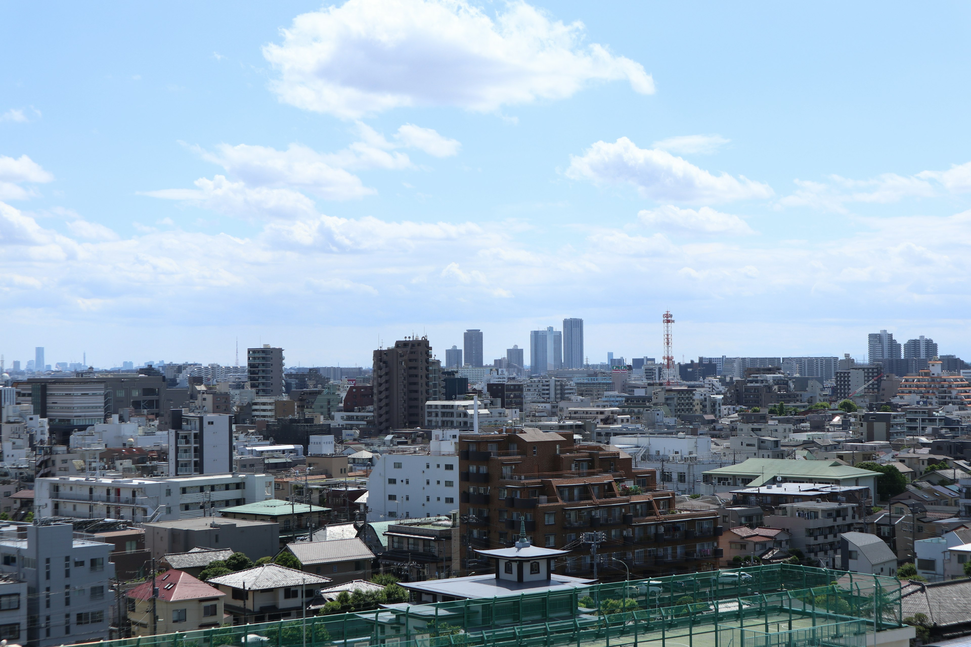 都市の風景と青空が広がる景色