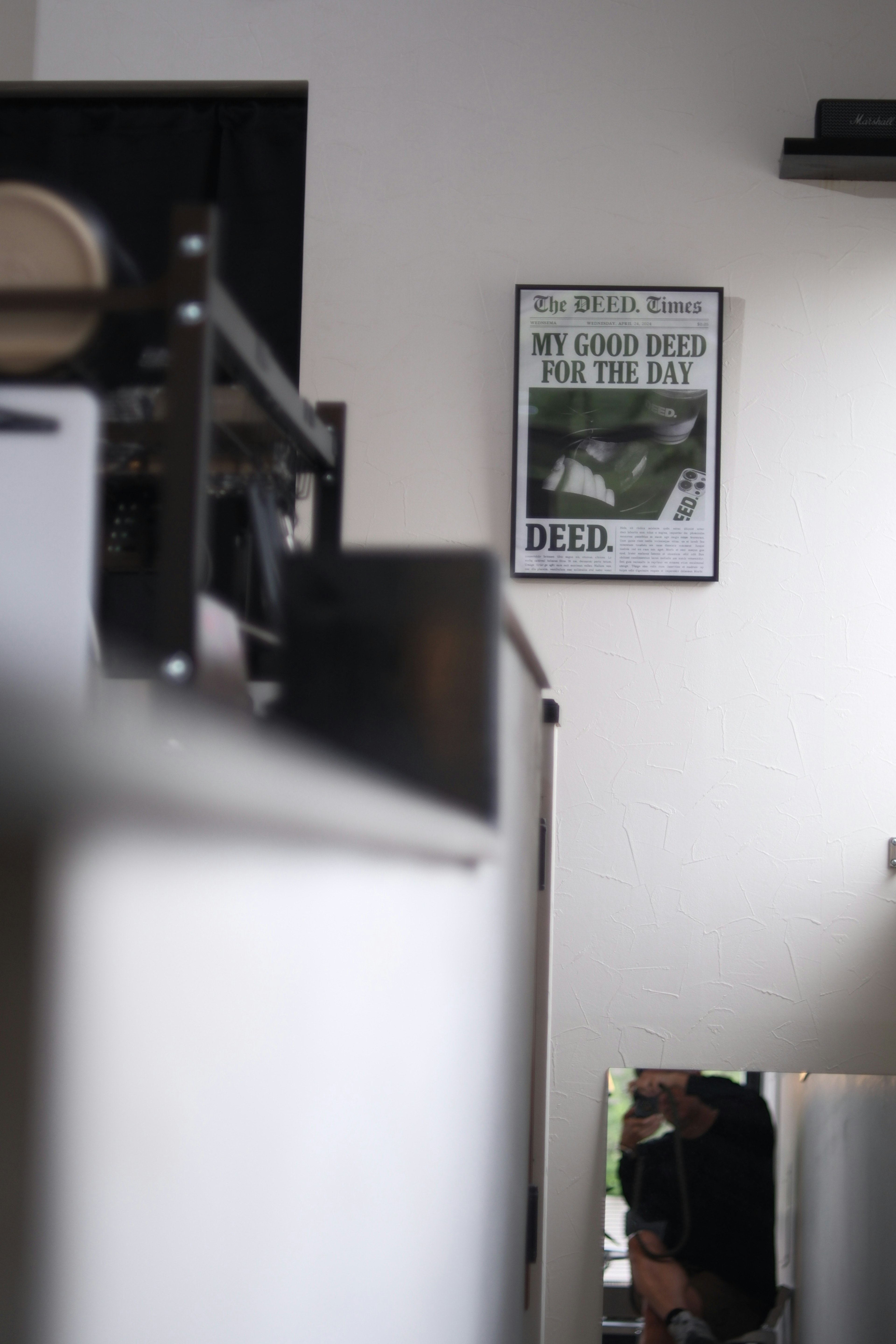 Interior of a cafe featuring white walls and black decor with a poster displaying a motivational message