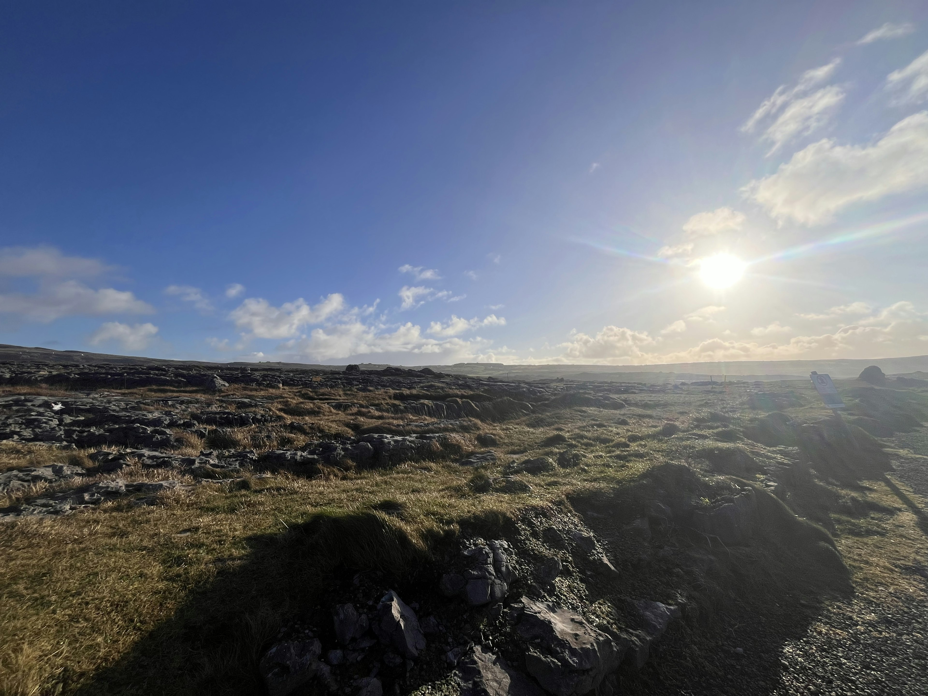 Scenic view of rocky terrain under a blue sky with sunlight