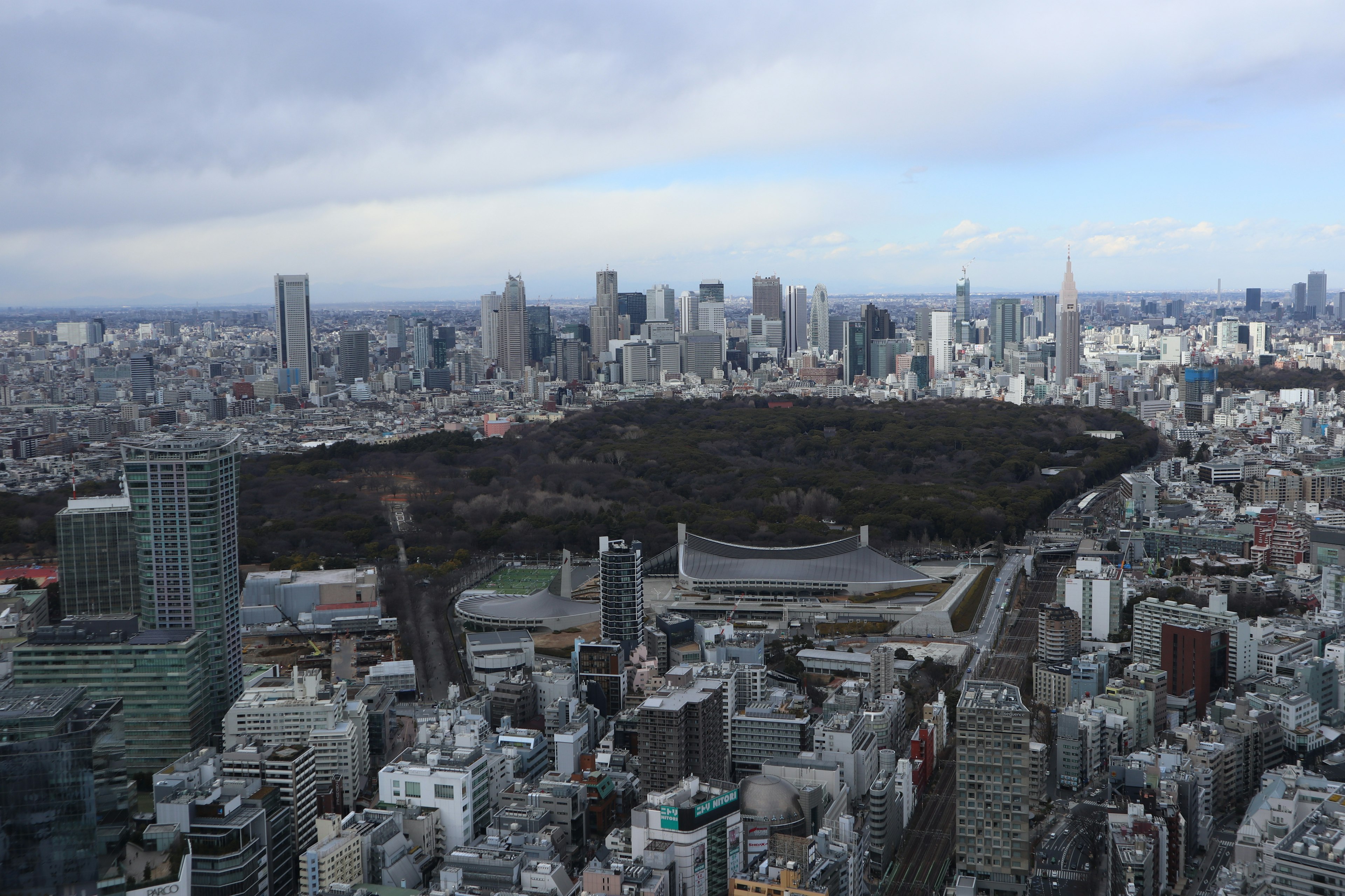 Aerial view of Tokyo skyline featuring Shinjuku Gyoen park amidst urban buildings