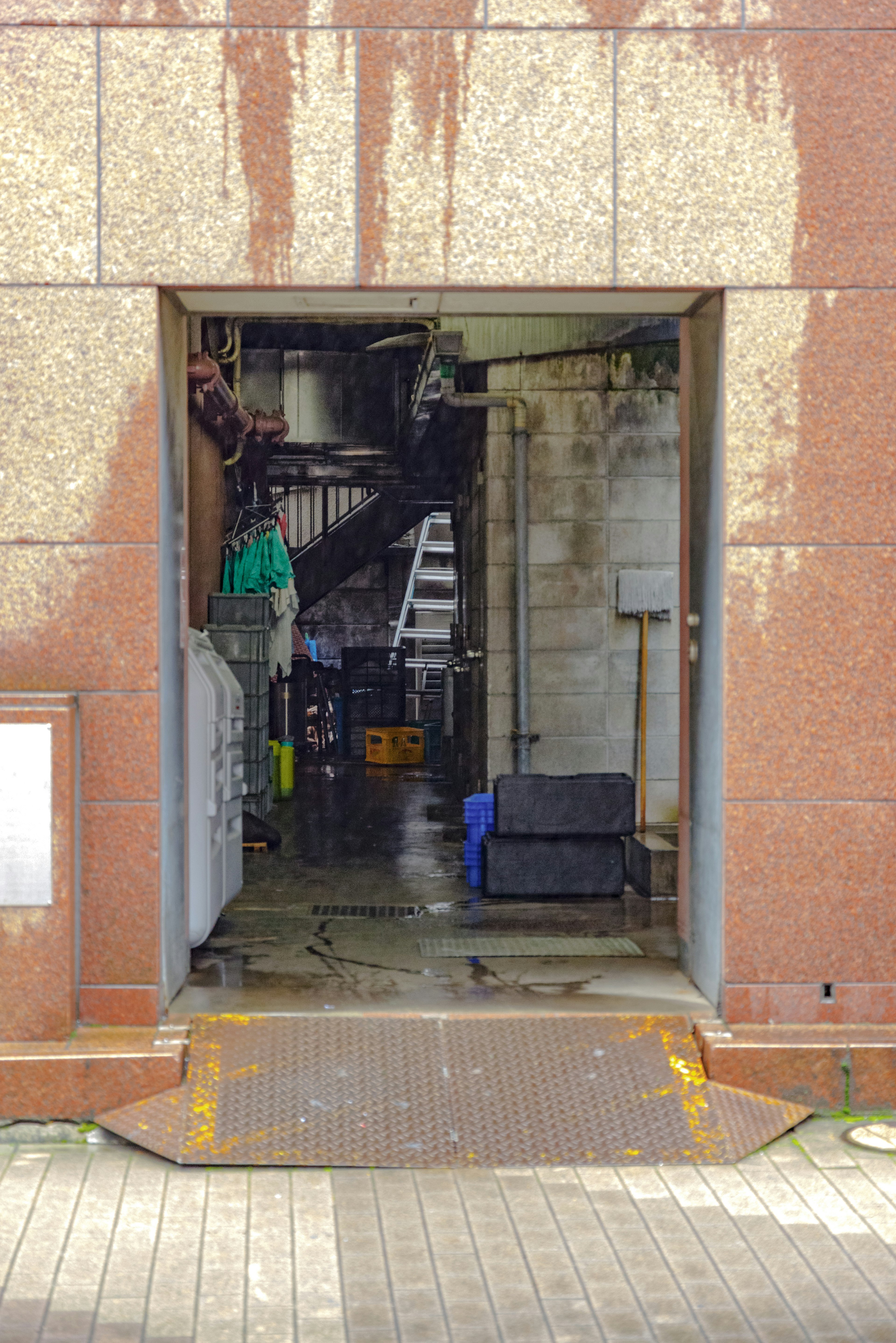 Vista de un pasillo oscuro y una escalera desde la entrada trasera de un edificio