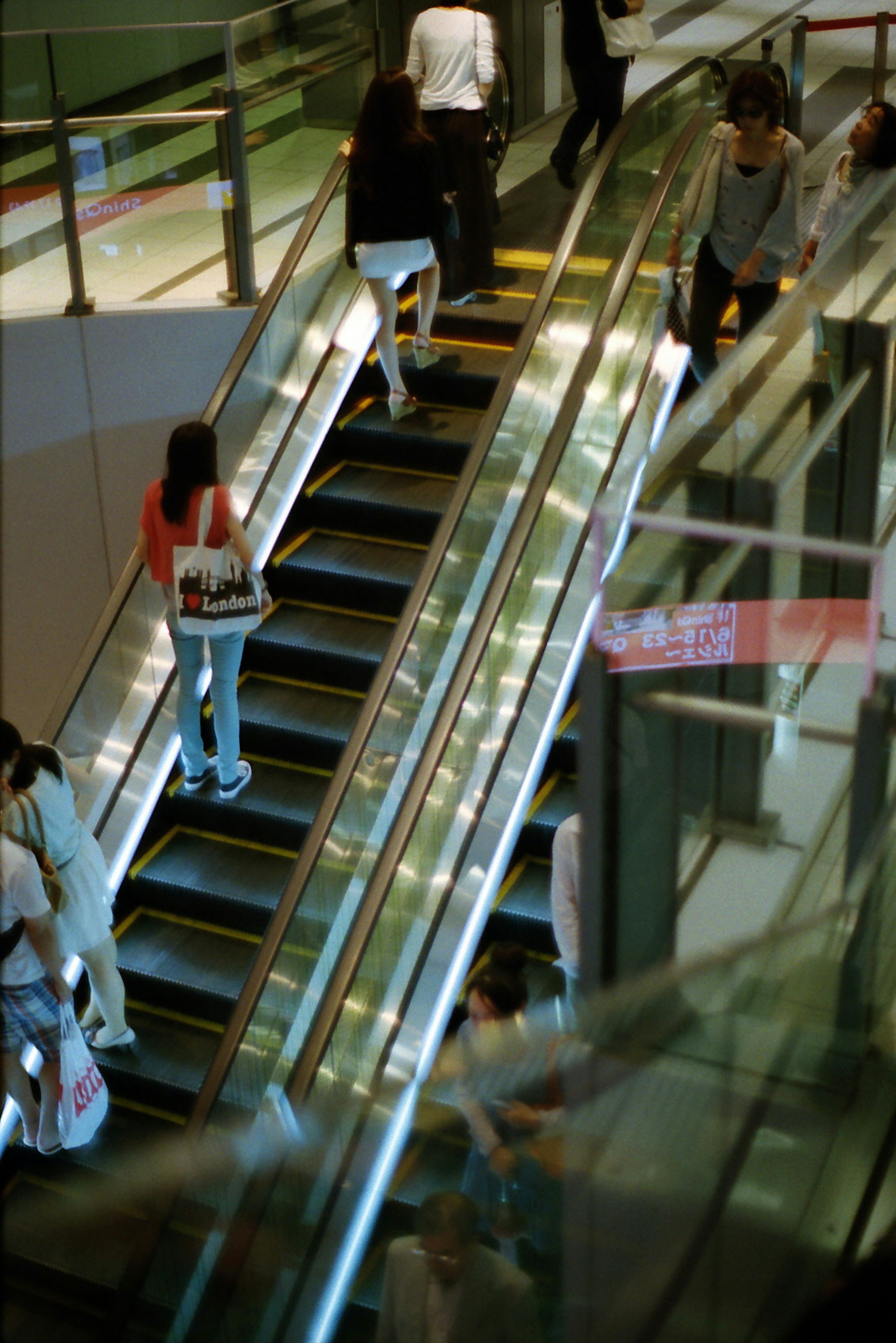 Personas utilizando una escalera mecánica en el interior de un edificio moderno