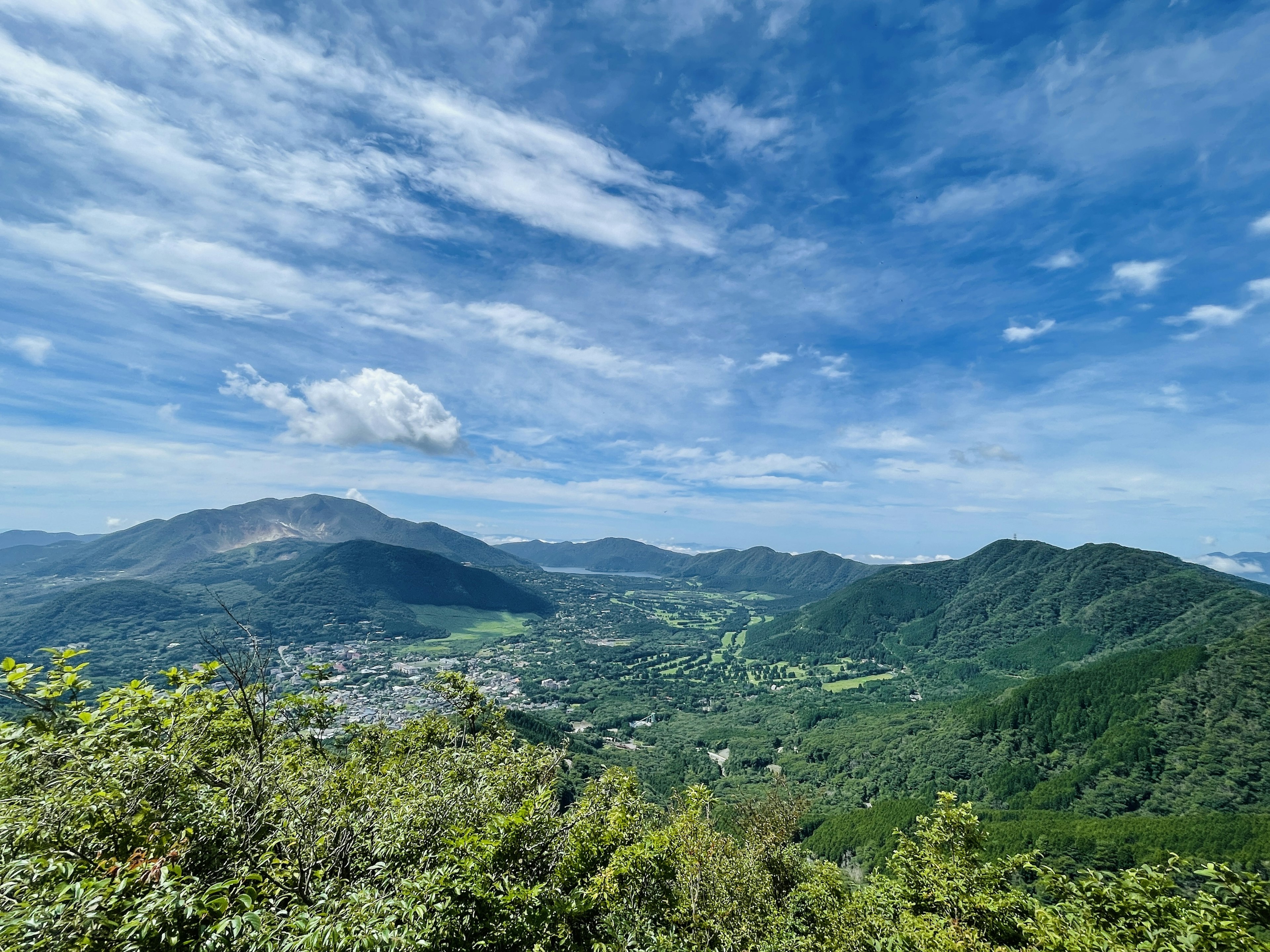 Schöne Landschaft mit Bergen und blauem Himmel mit Grünflächen und einem Dorf unten