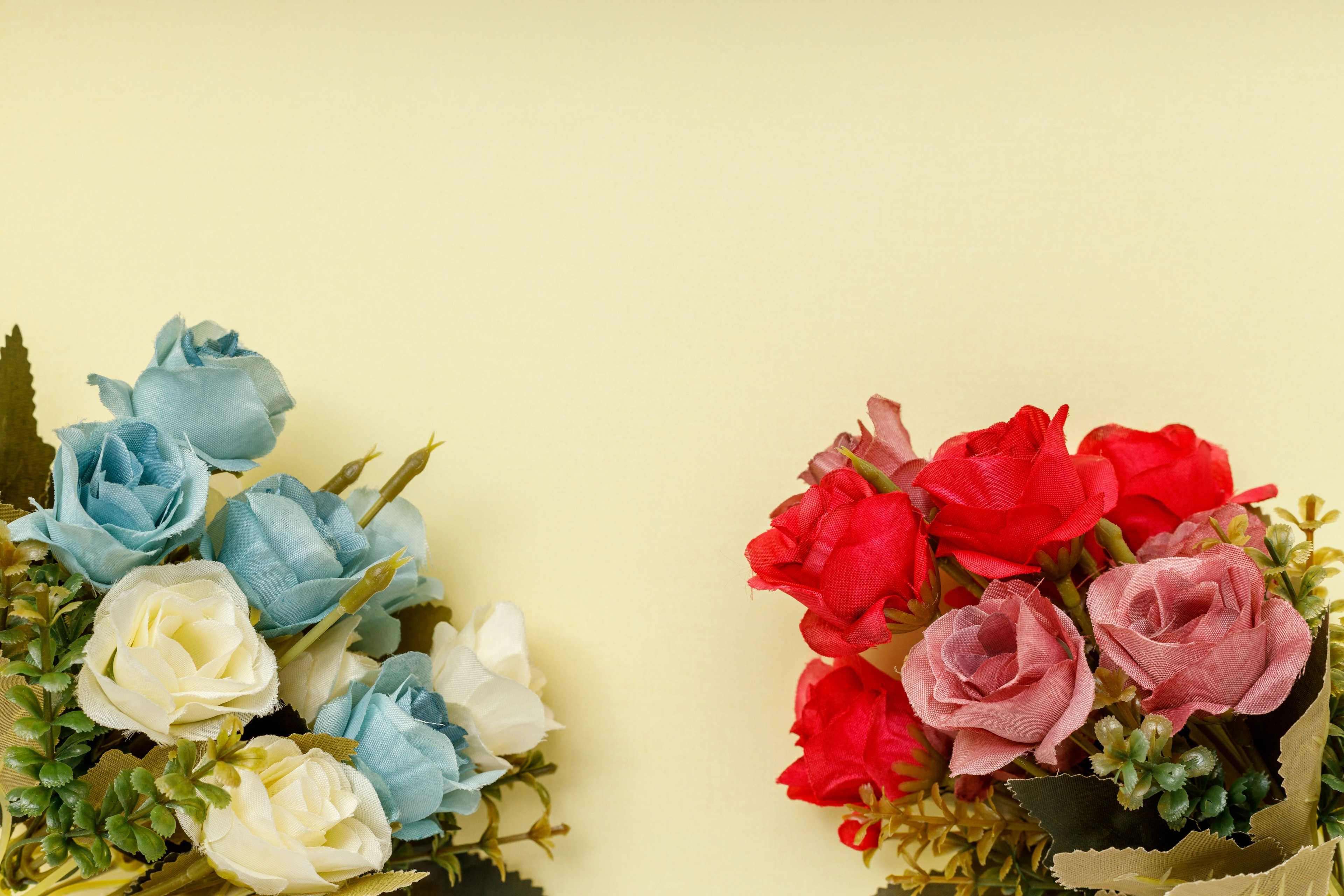 Bouquets de fleurs bleues et rouges disposés sur un fond jaune