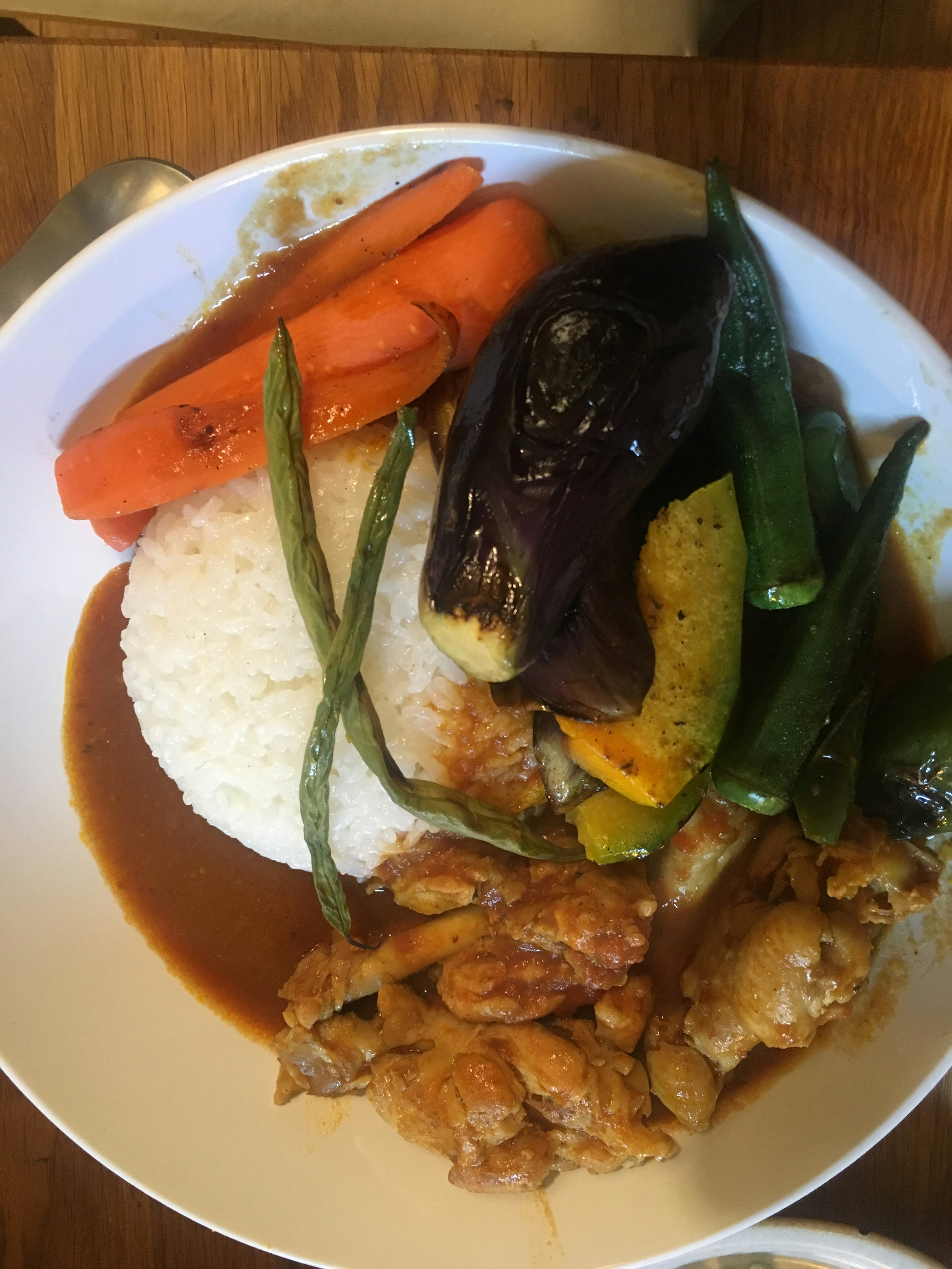 Plato de arroz cubierto con pollo y verduras variadas