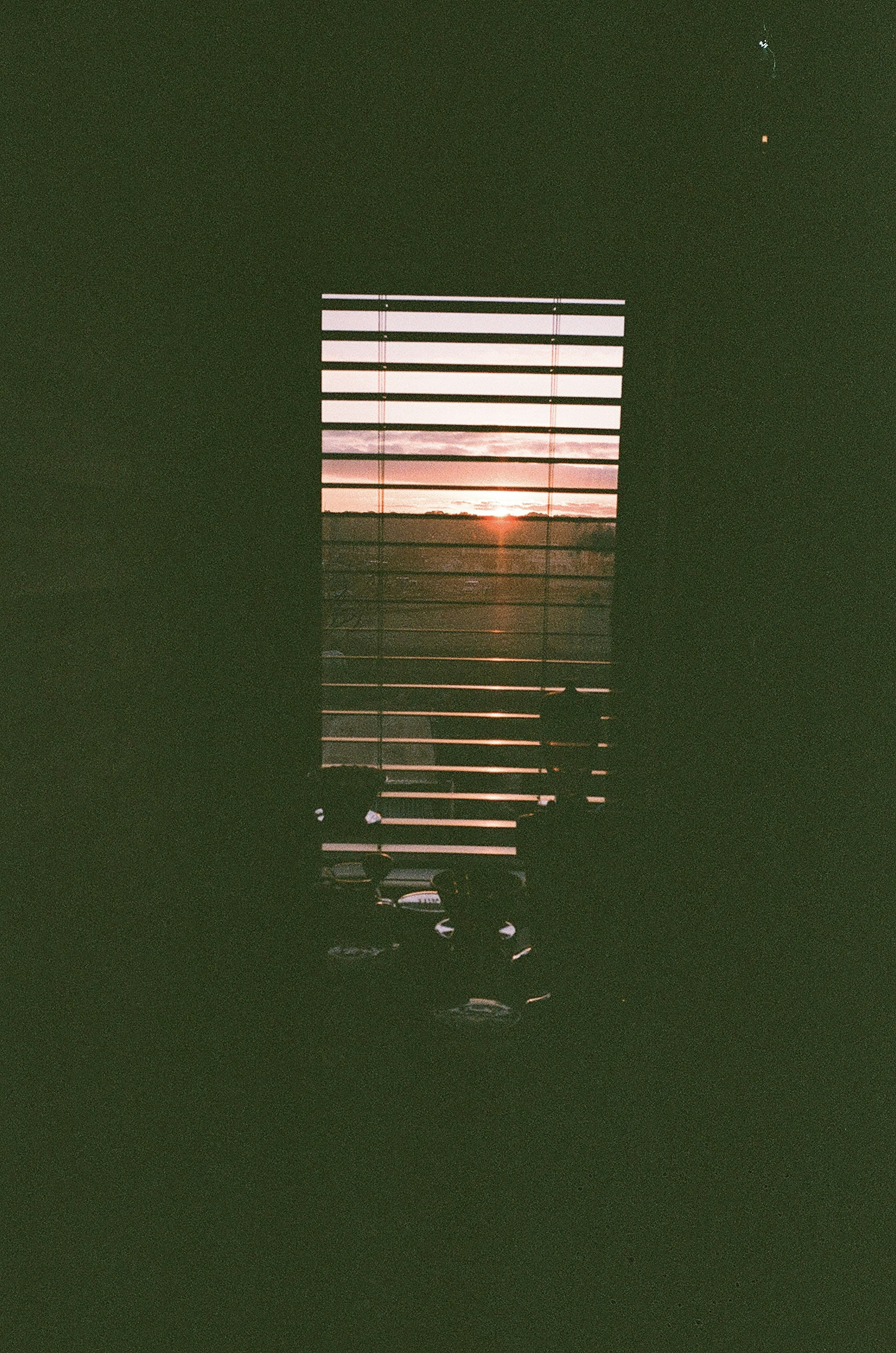 Sunset view through blinds with dark interior