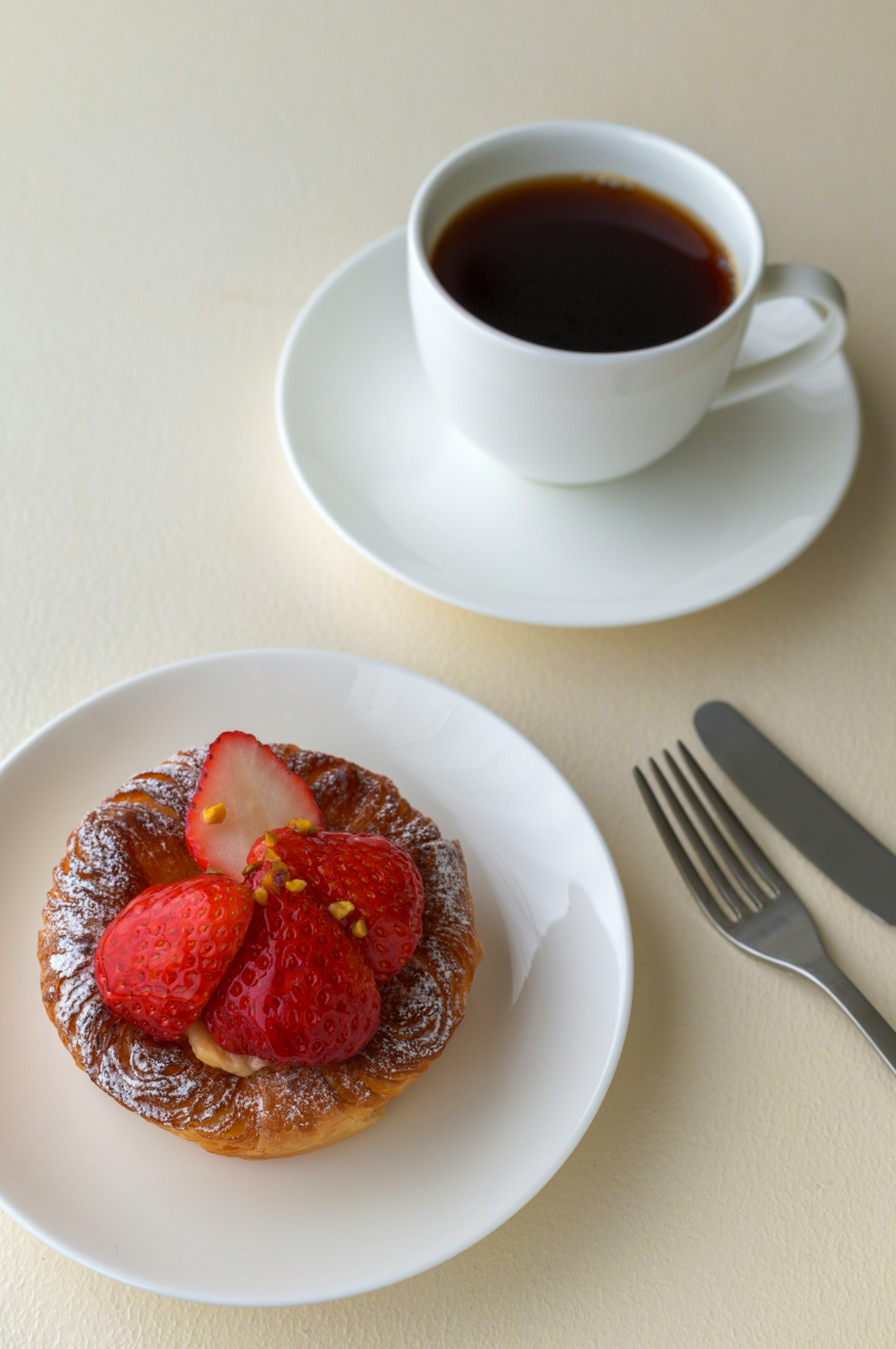 Table setting with coffee and strawberry tart