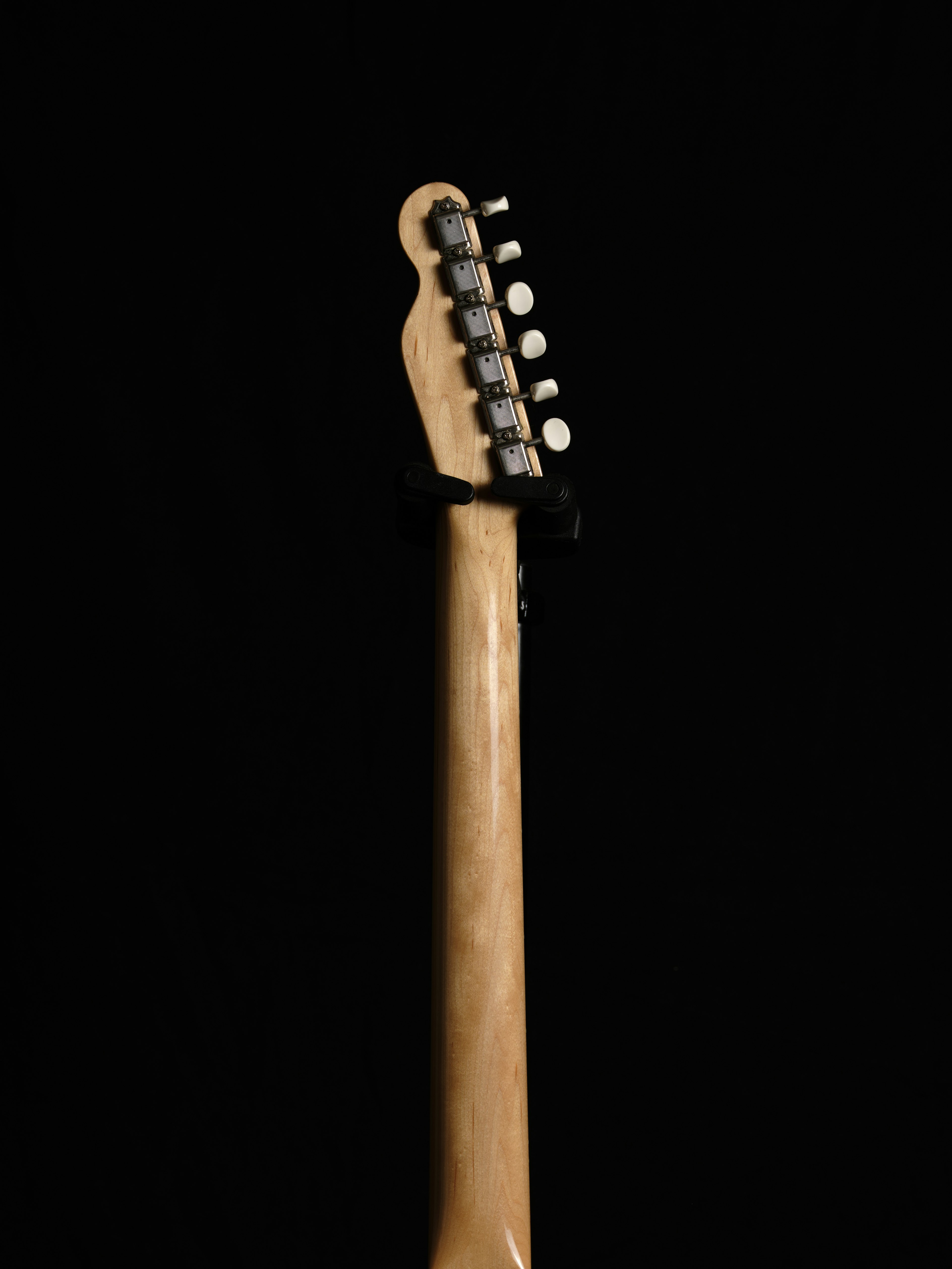 Guitar headstock against a black background