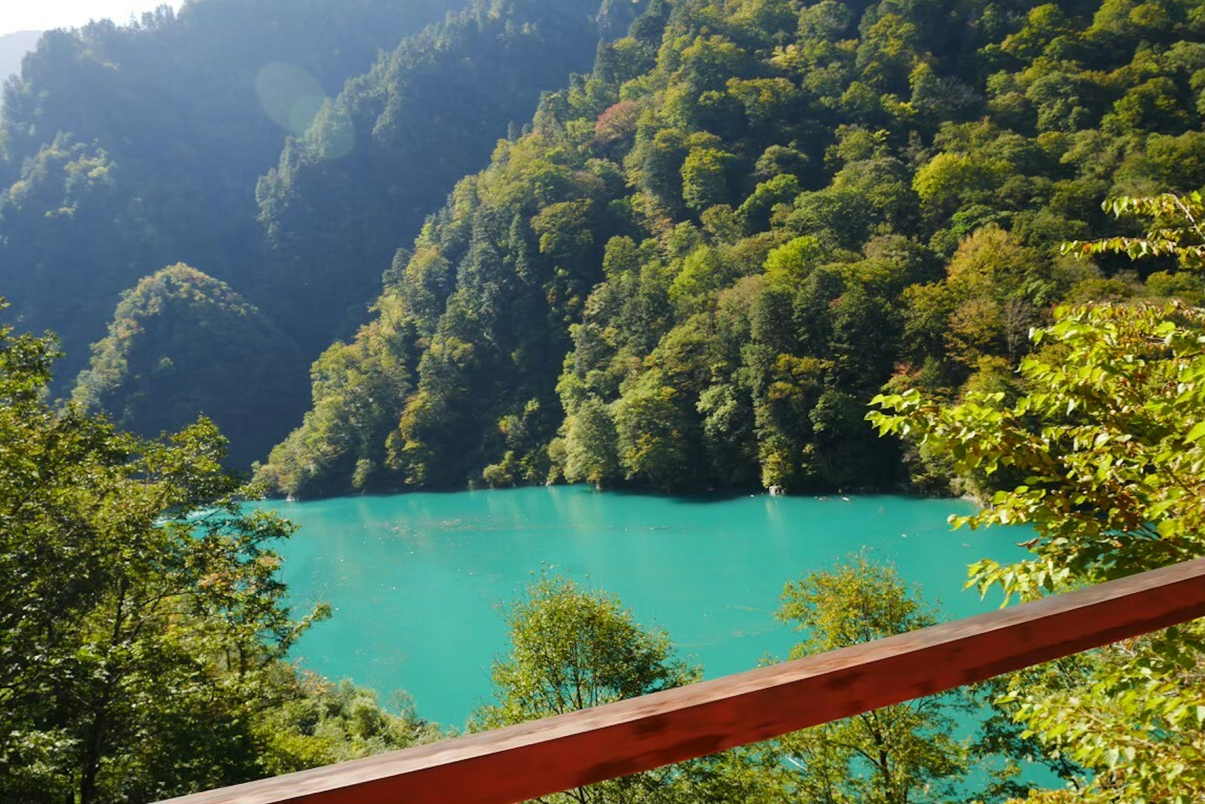 Scenic view of a turquoise lake surrounded by lush green mountains