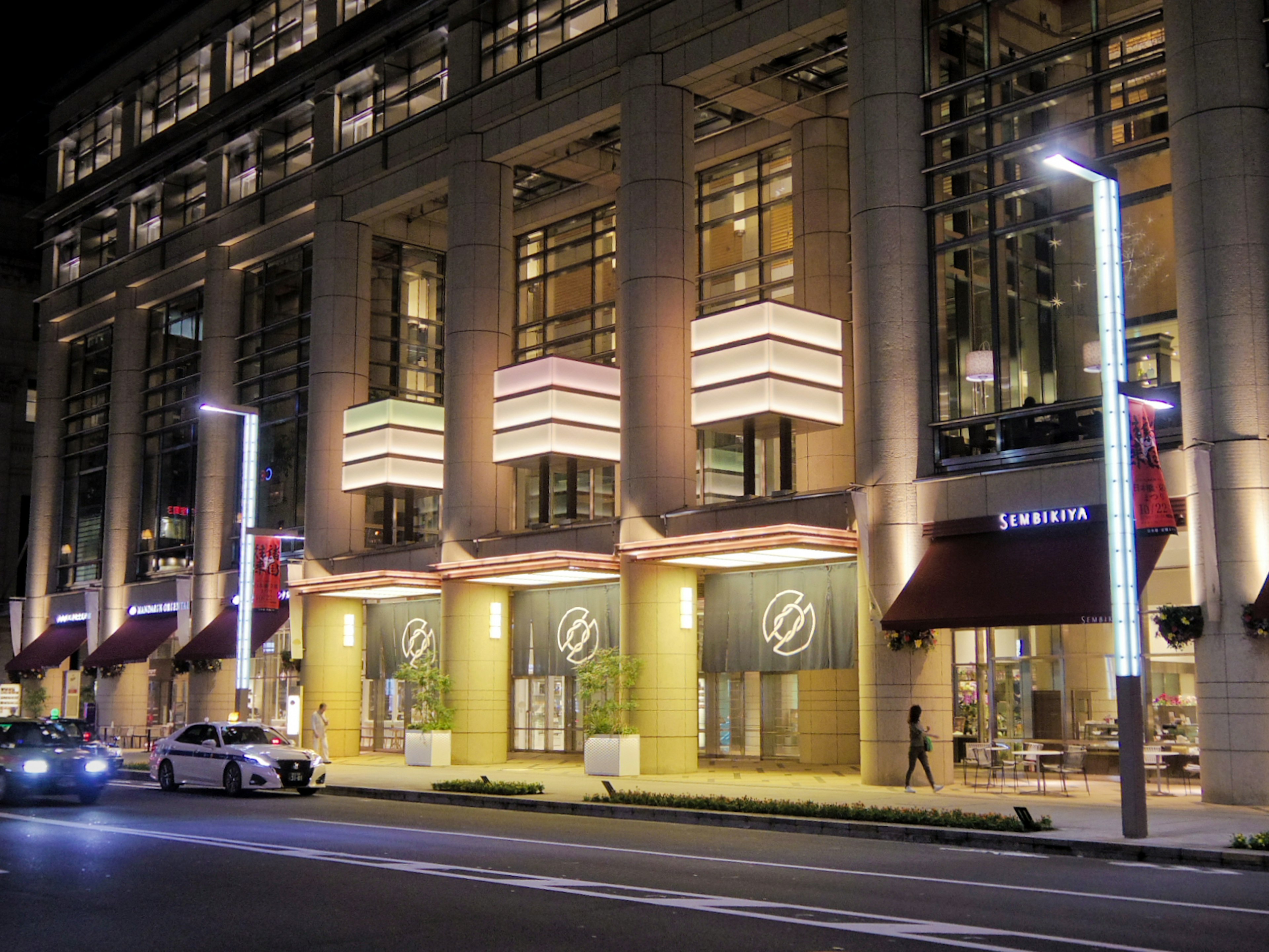 Modern building exterior illuminated at night with street lights