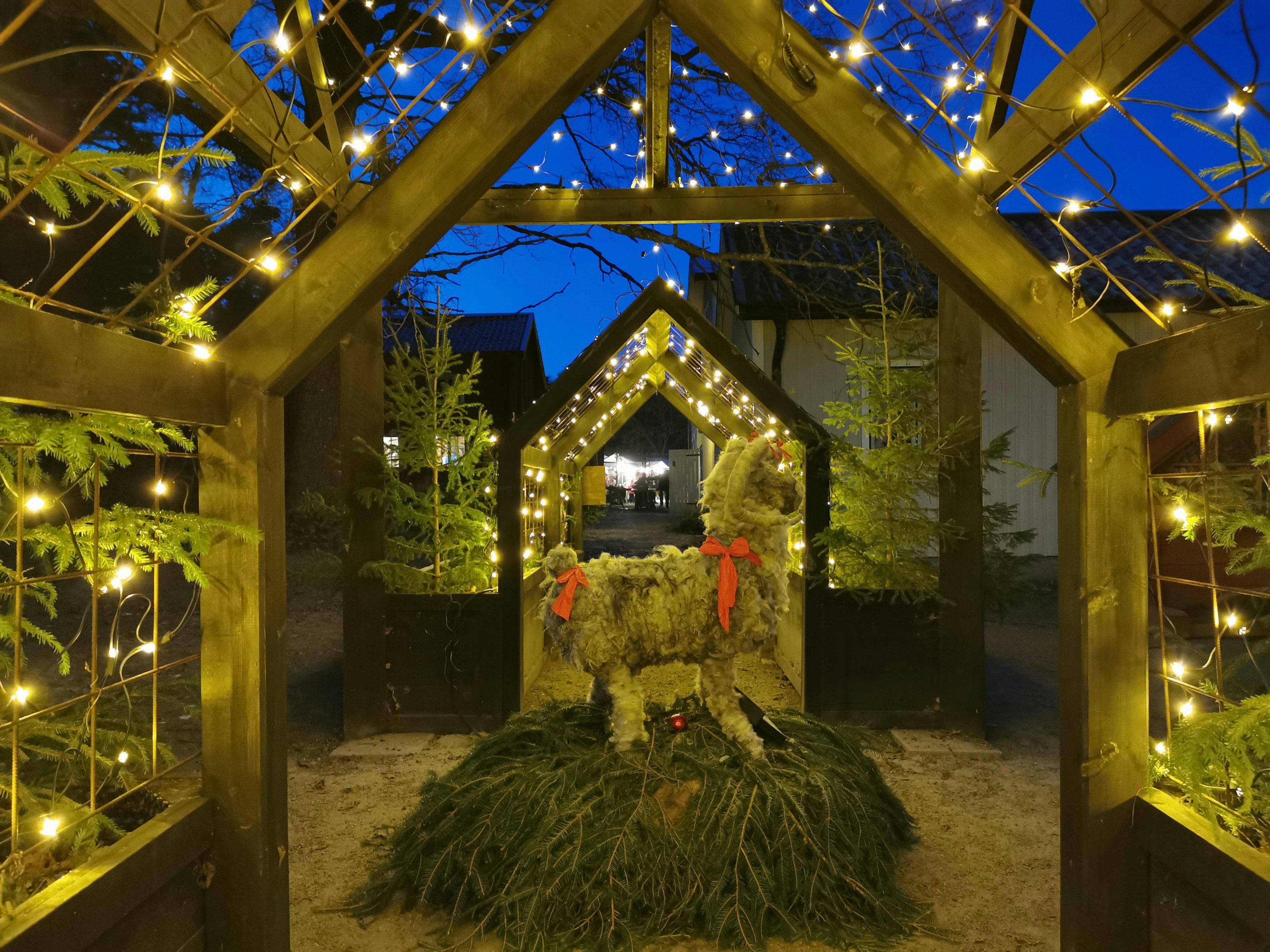 Illuminated archway with Christmas decorations under a blue night sky