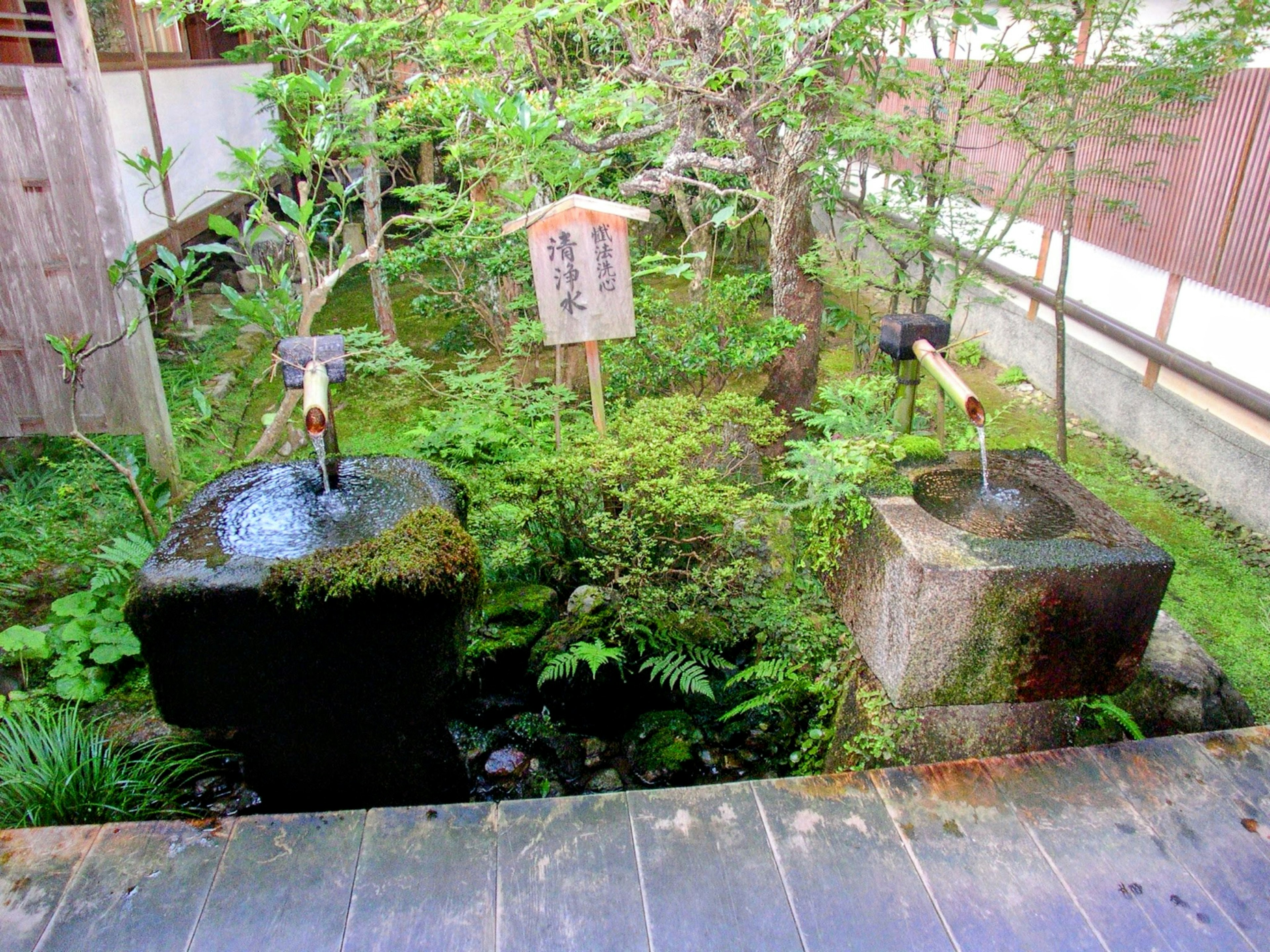 Zwei Steinbecken in einem Garten umgeben von Grün