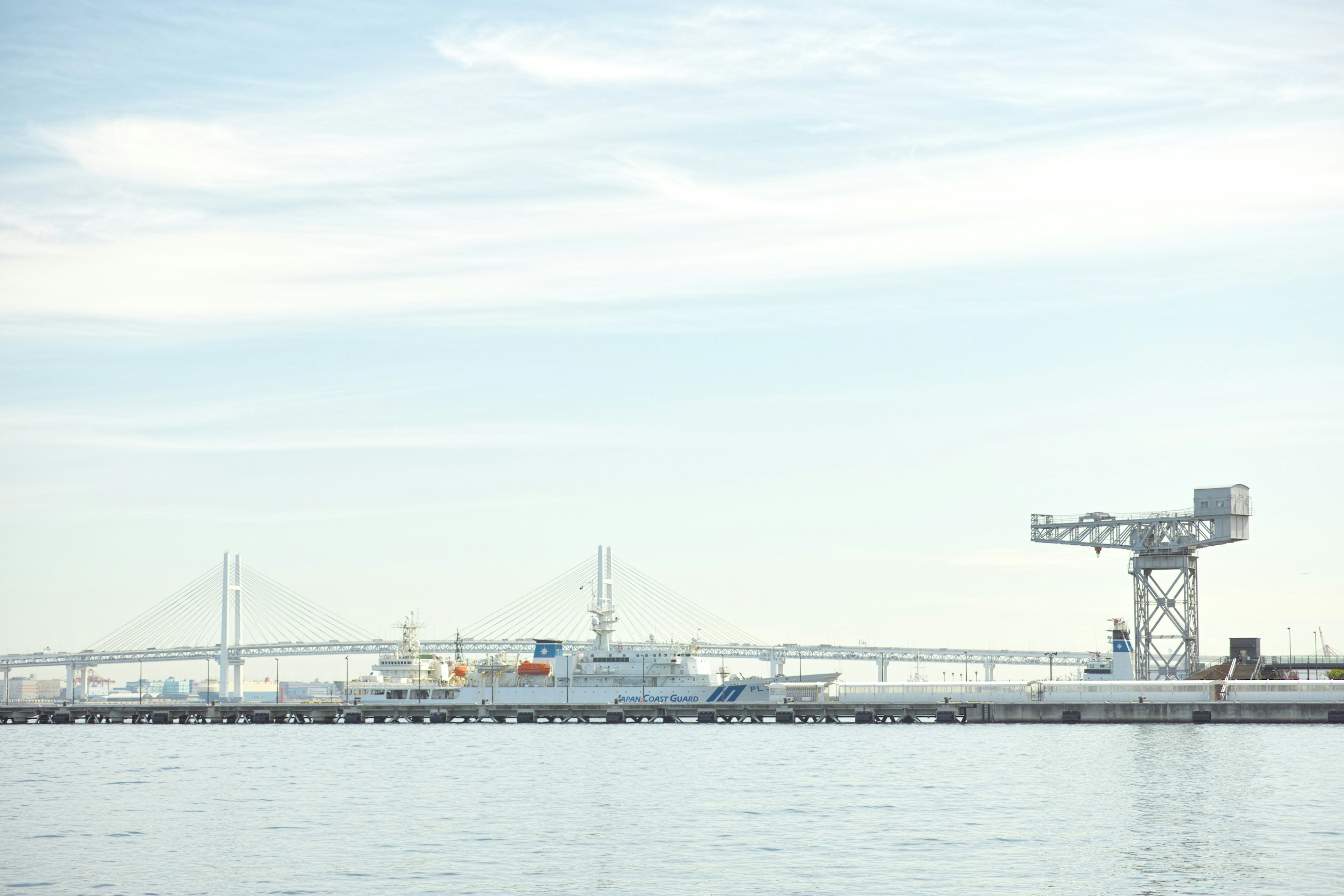 Harbor view with a crane and distant bridge