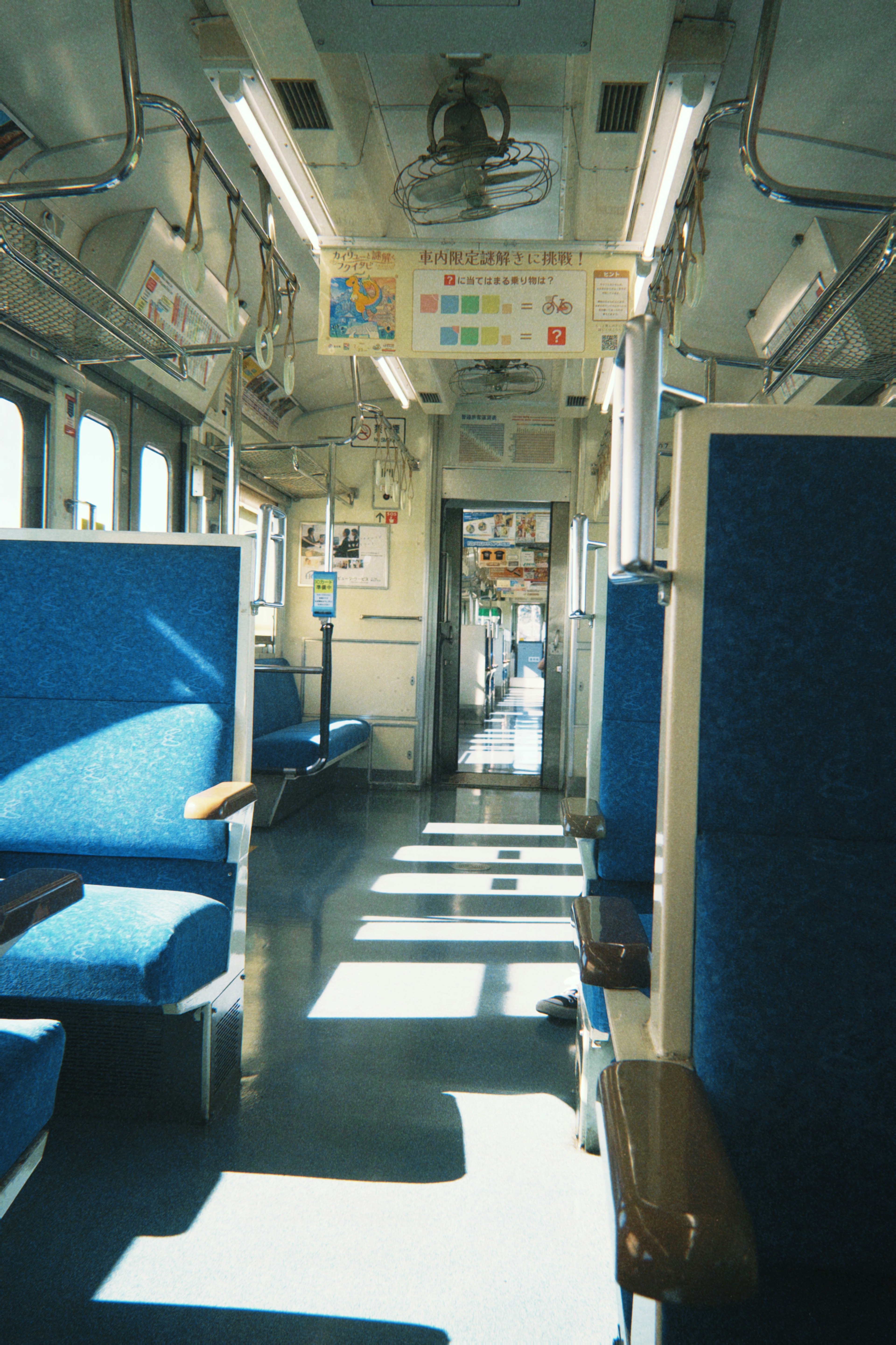 Vista interior de un vagón de tren con asientos azules