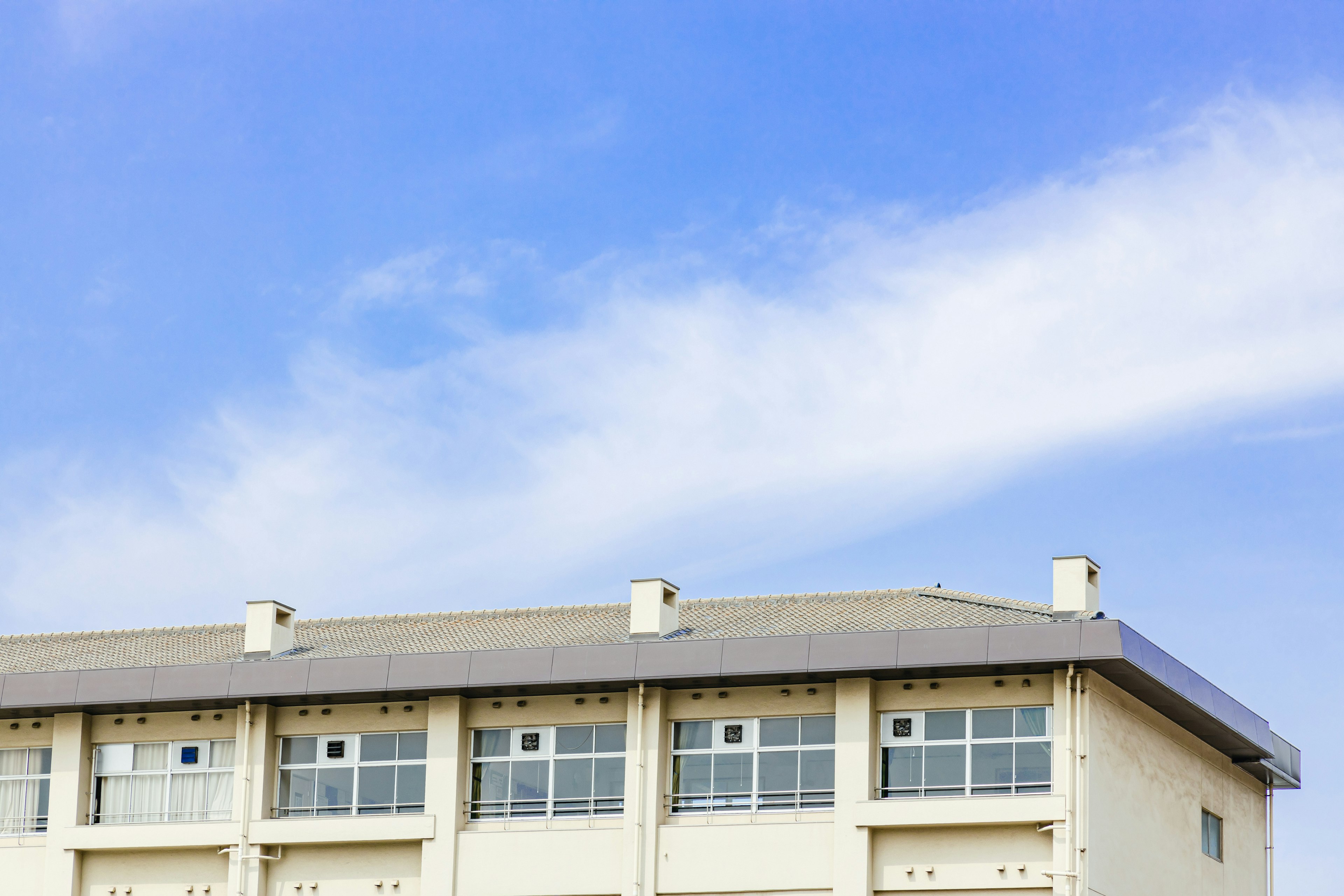 Oberer Teil eines weißen Gebäudes unter blauem Himmel