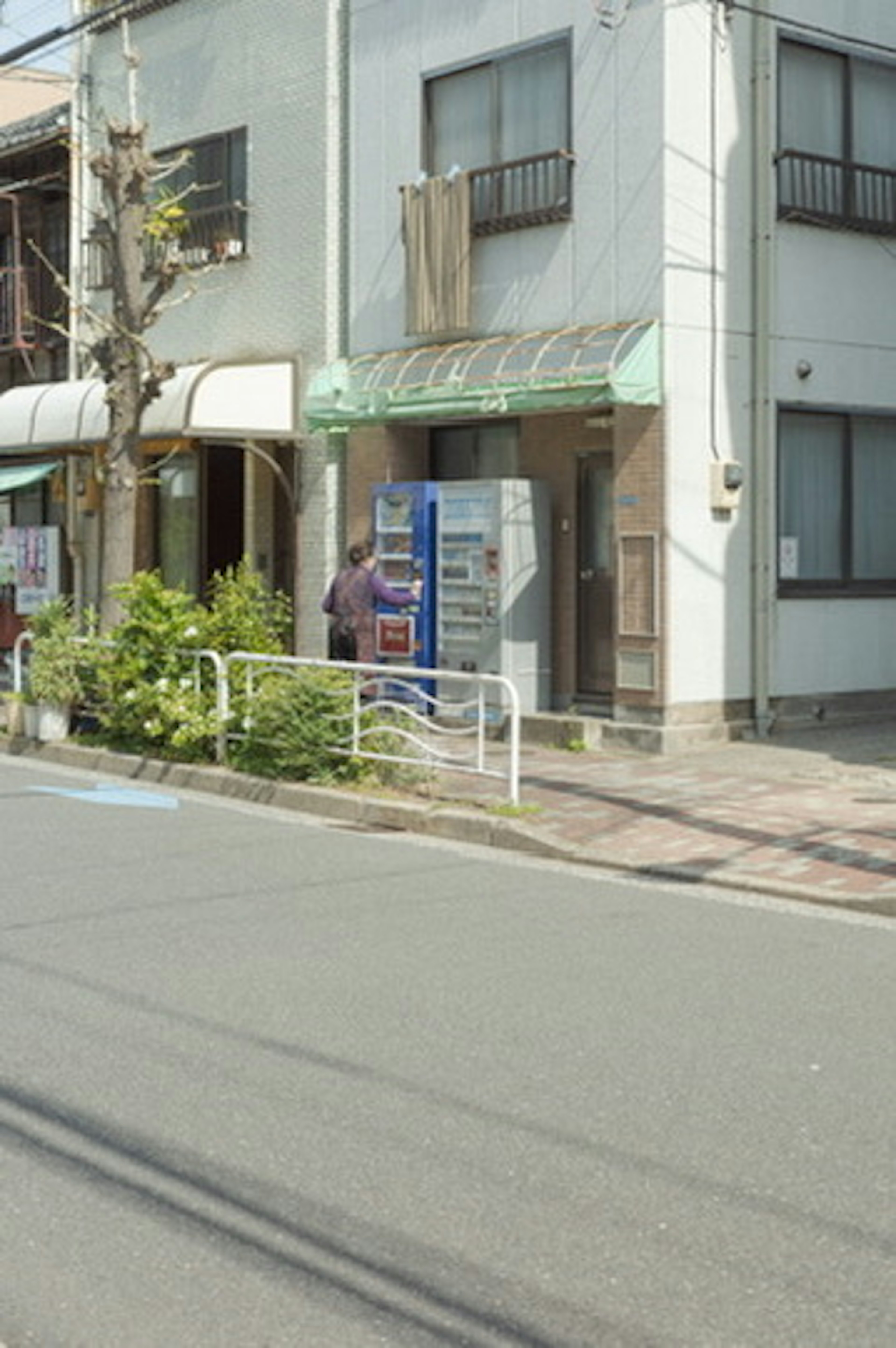 街の通りにある小さな店舗と自動販売機