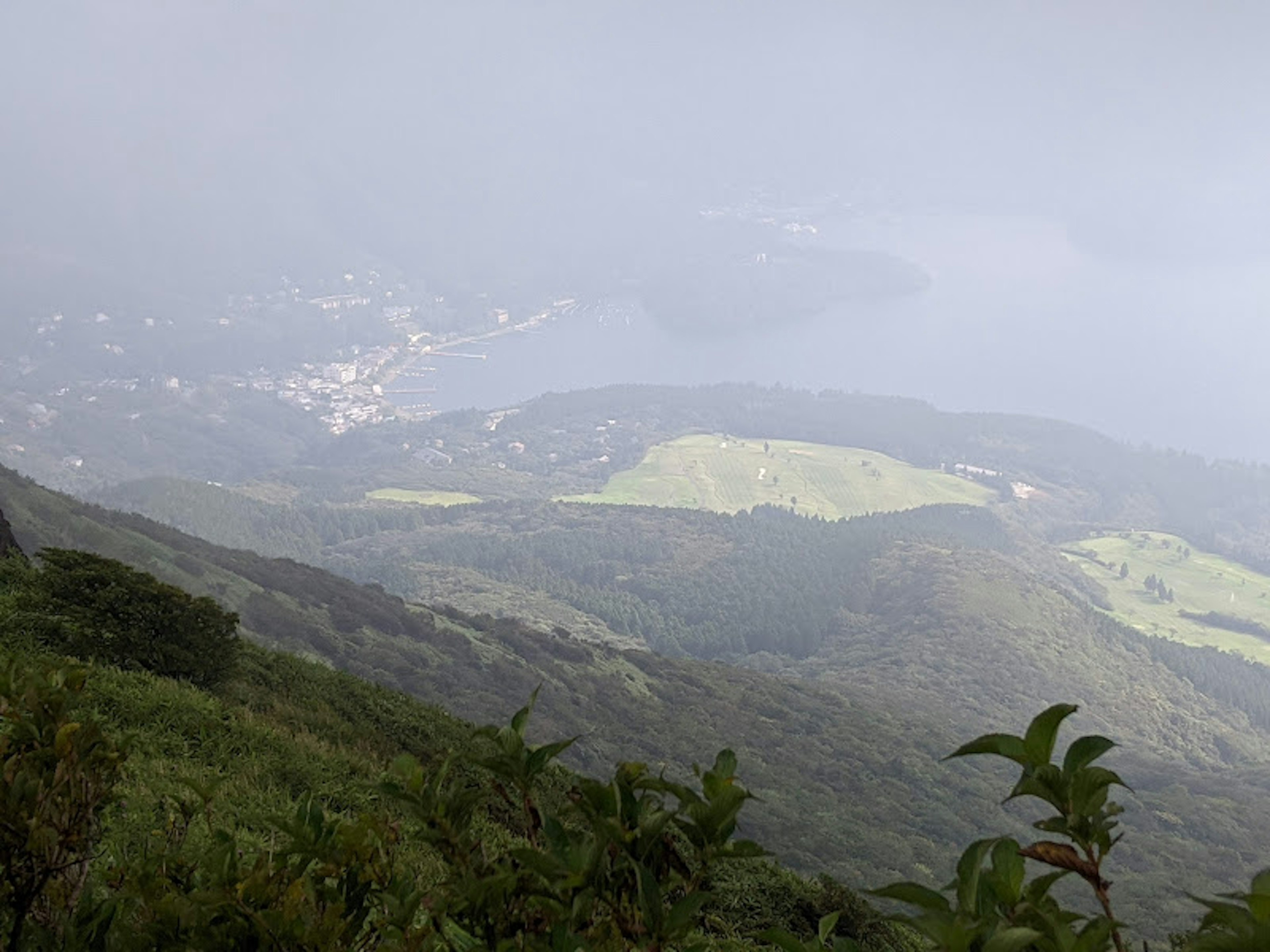 Mountain landscape shrouded in mist with a distant town