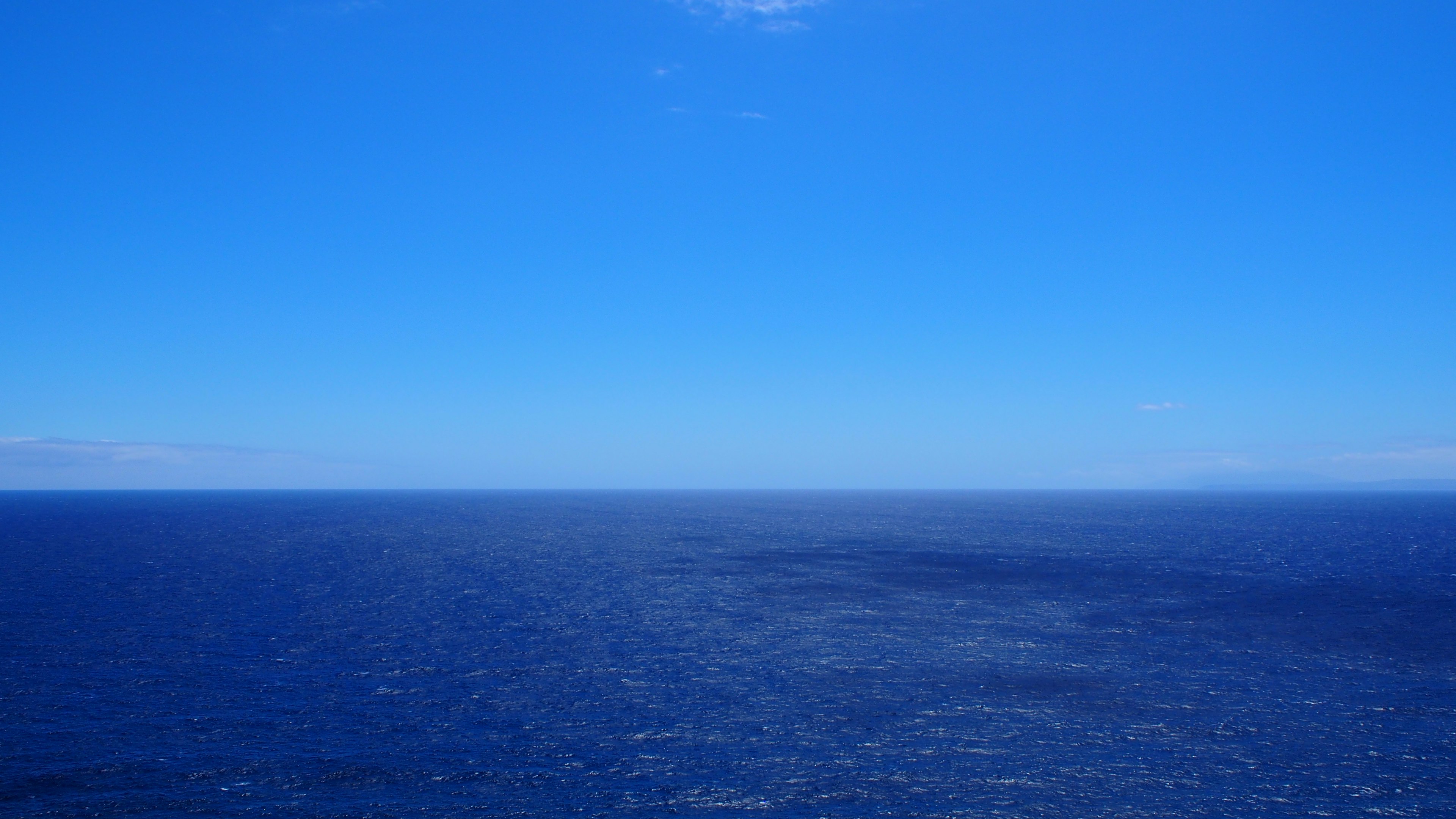 Weites blaues Meer, das den klaren Himmel trifft