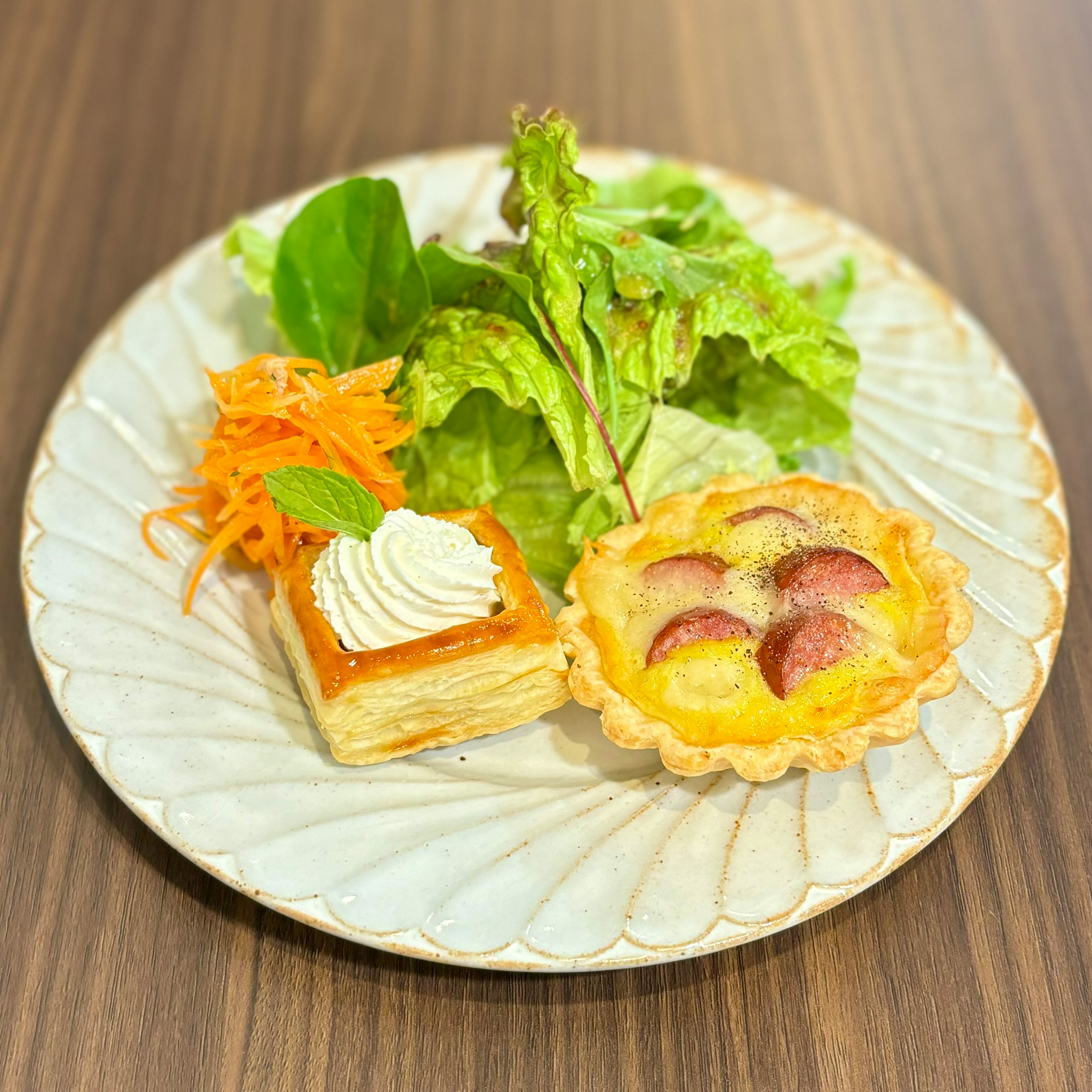 Đĩa salad và món tráng miệng với xà lách salad cà rốt bánh kem và bánh tart trái cây