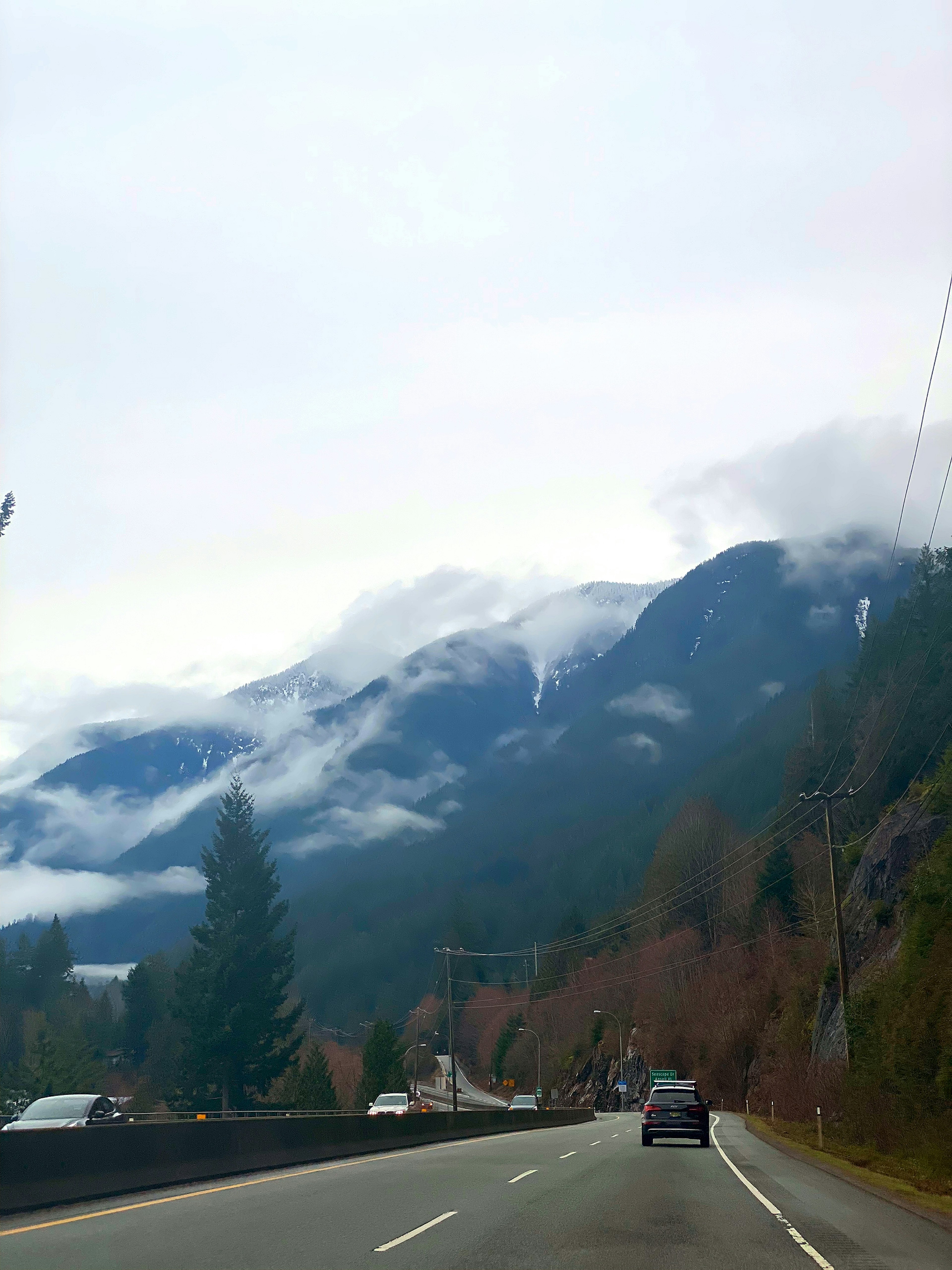 Vista panoramica di montagne coperte di nebbia accanto a una strada