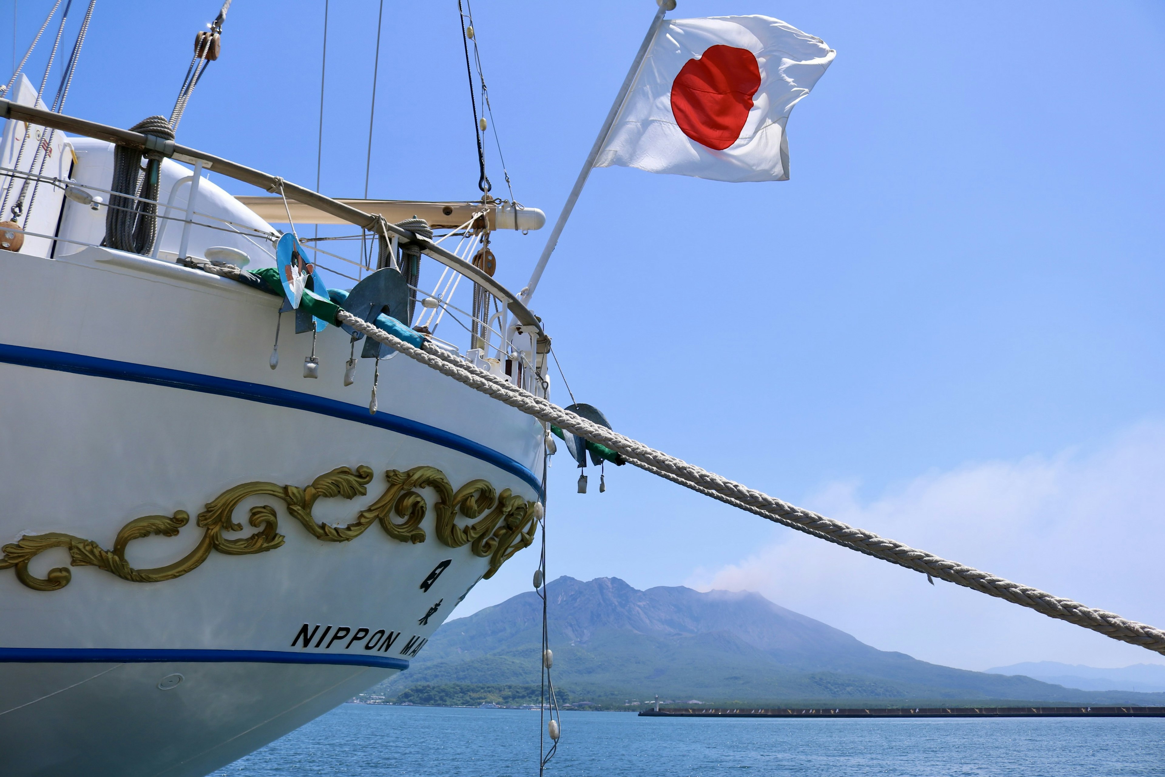 Bow of a ship displaying the Japanese flag with a view of blue sea