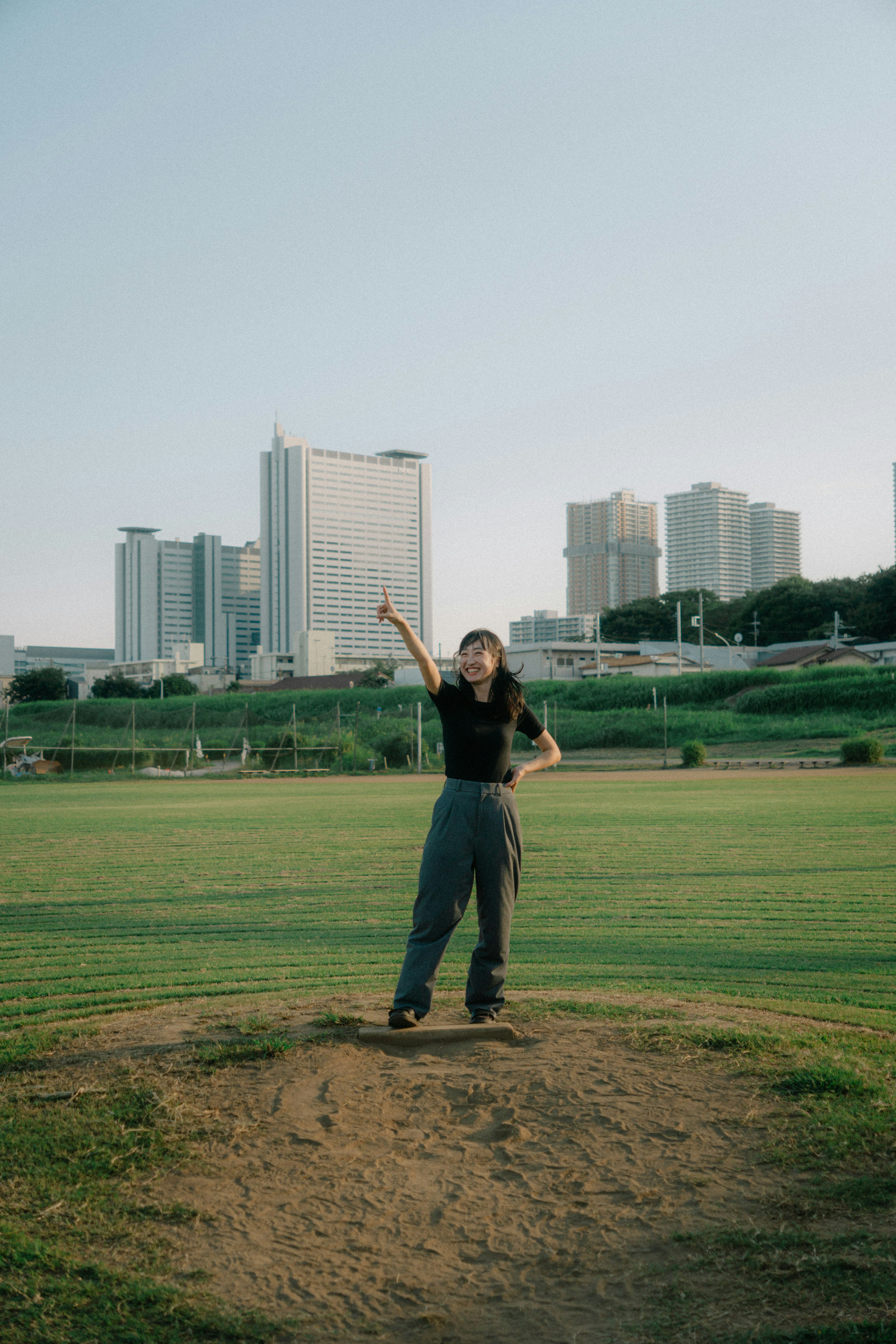 Una mujer posando en un parque con rascacielos al fondo