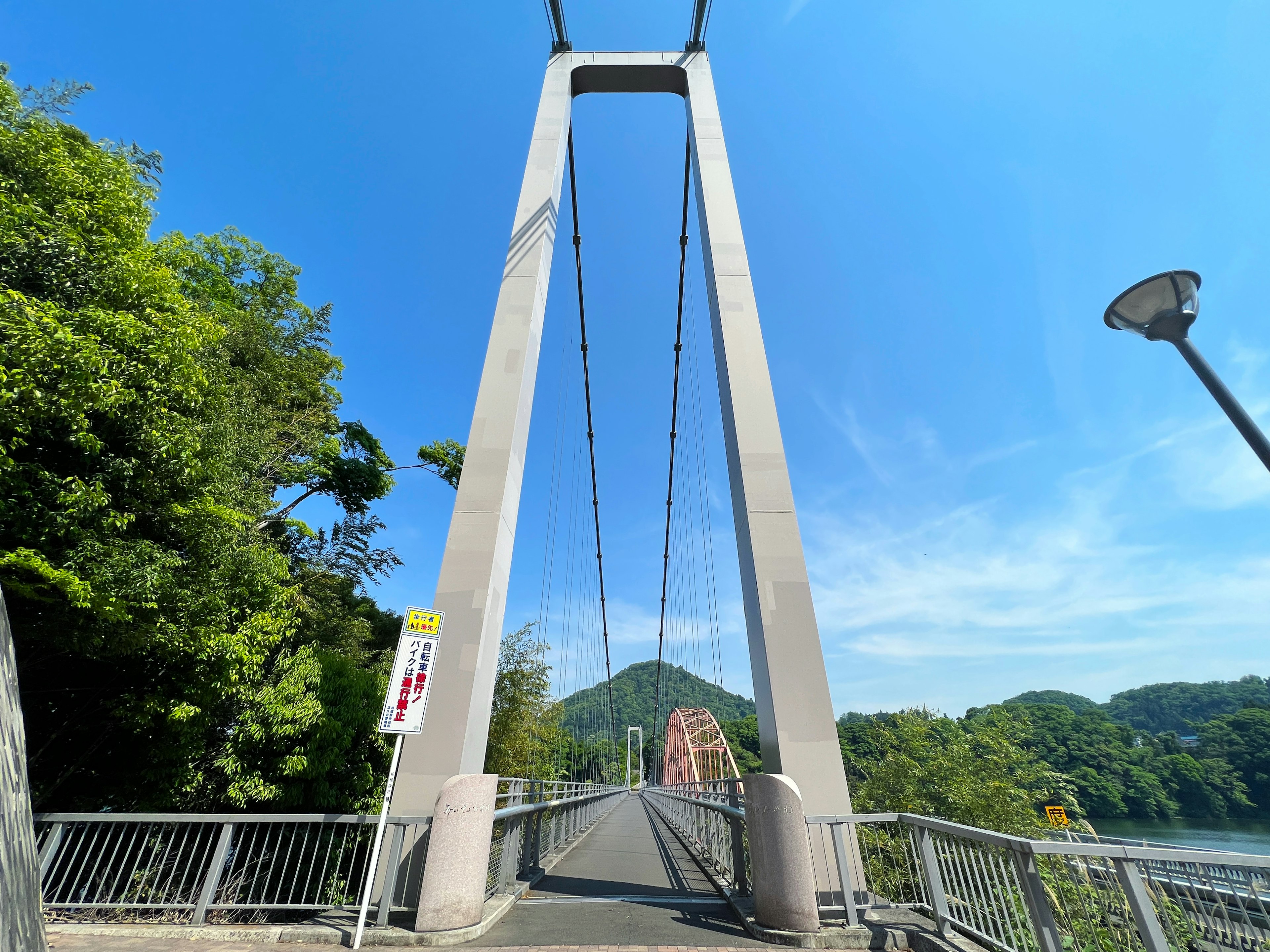 青空の下にある吊り橋と緑豊かな山々