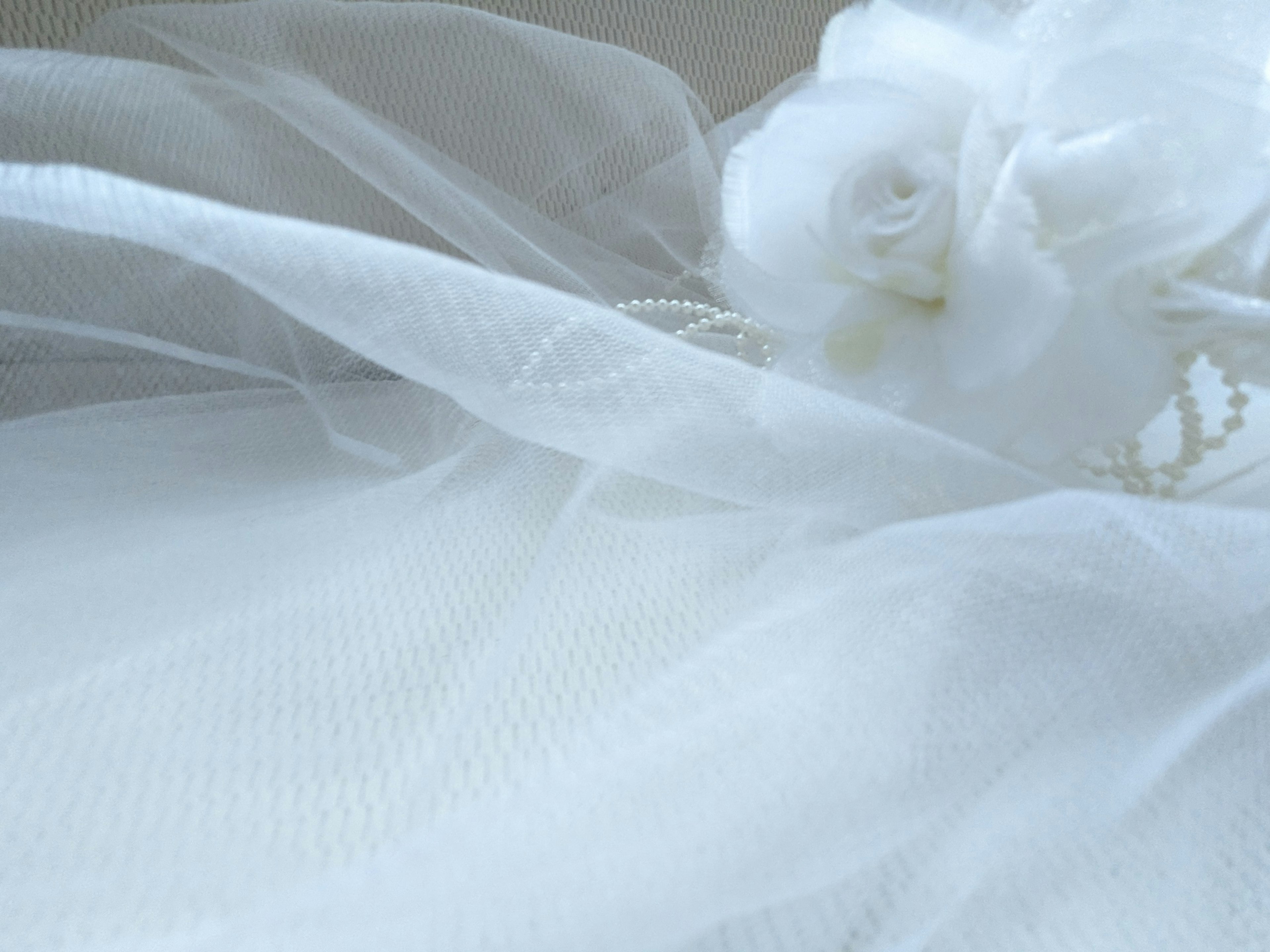 Dettaglio bello di un abito da sposa con tulle bianco e un fiore