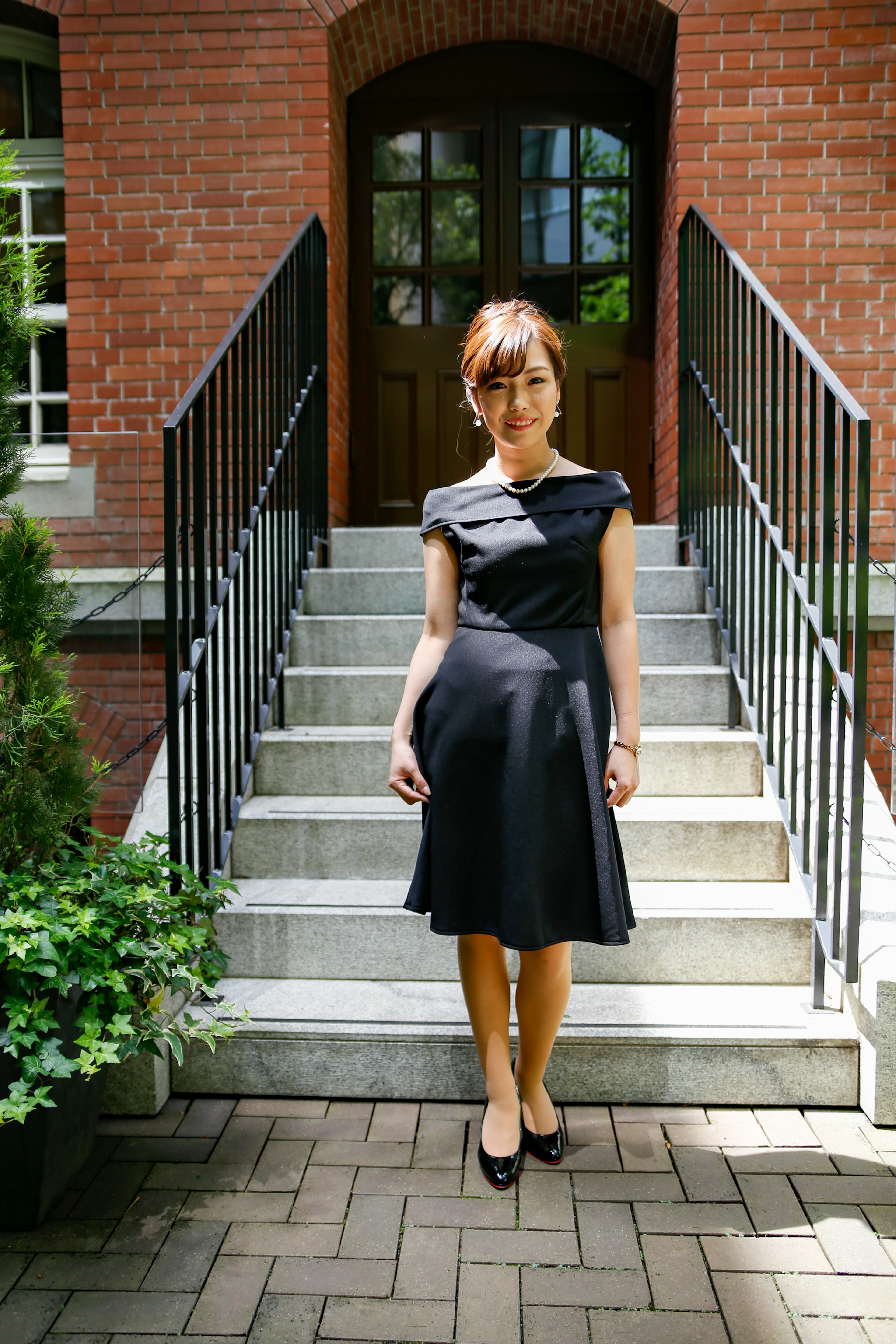 Eine Frau in einem schwarzen Kleid steht auf einer Treppe