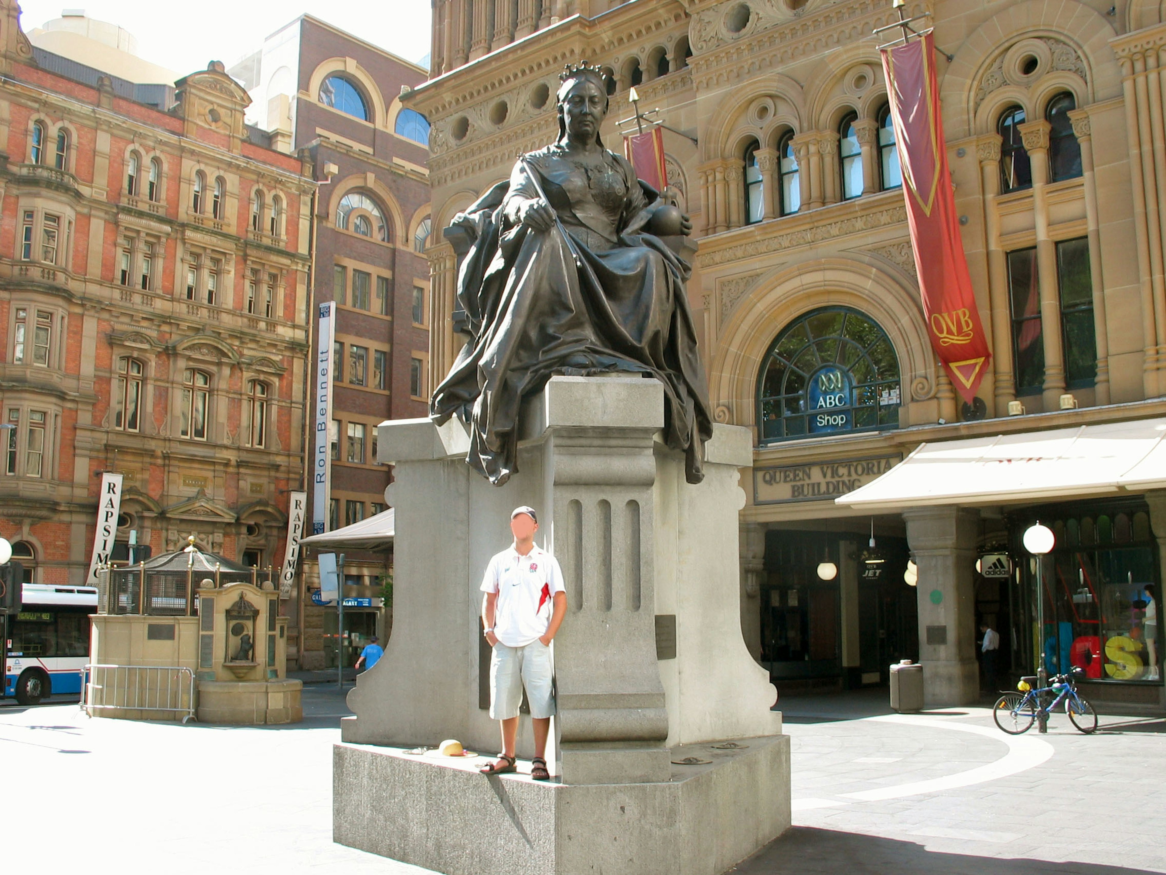 Mann steht vor einer Statue mit historischen Gebäuden im Hintergrund