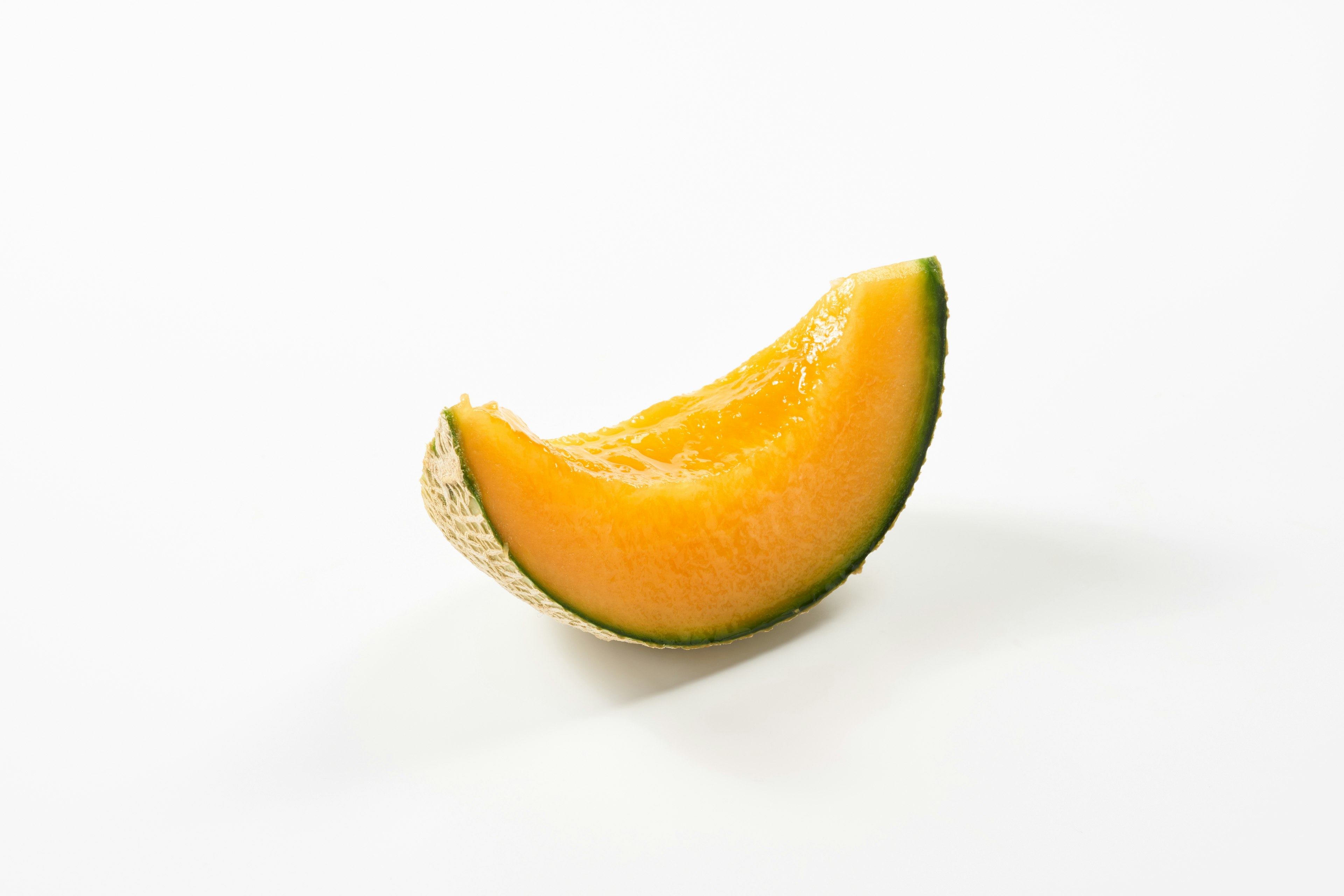 A slice of orange melon on a white background