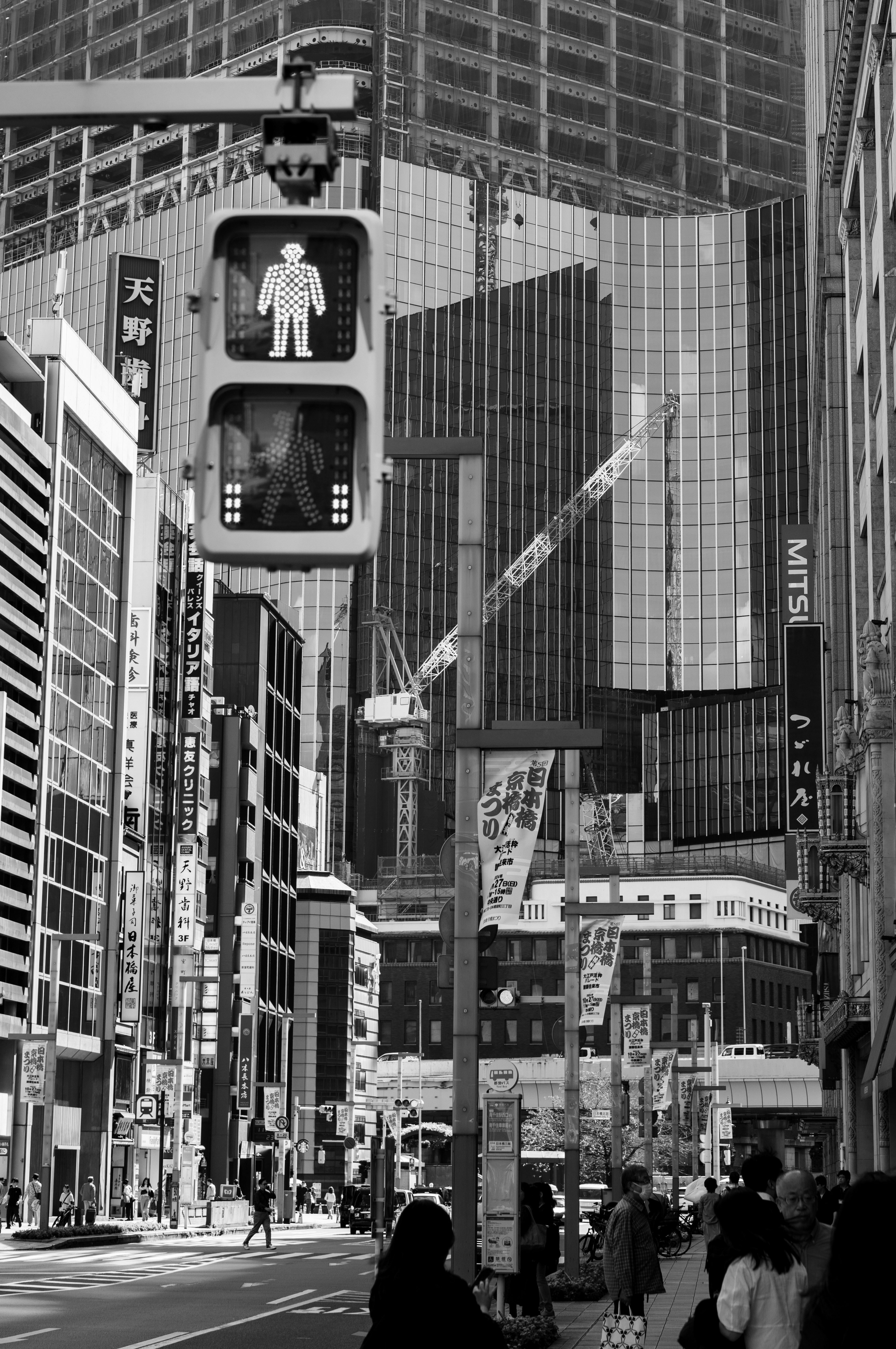 Foto en blanco y negro de un semáforo y rascacielos en una intersección urbana