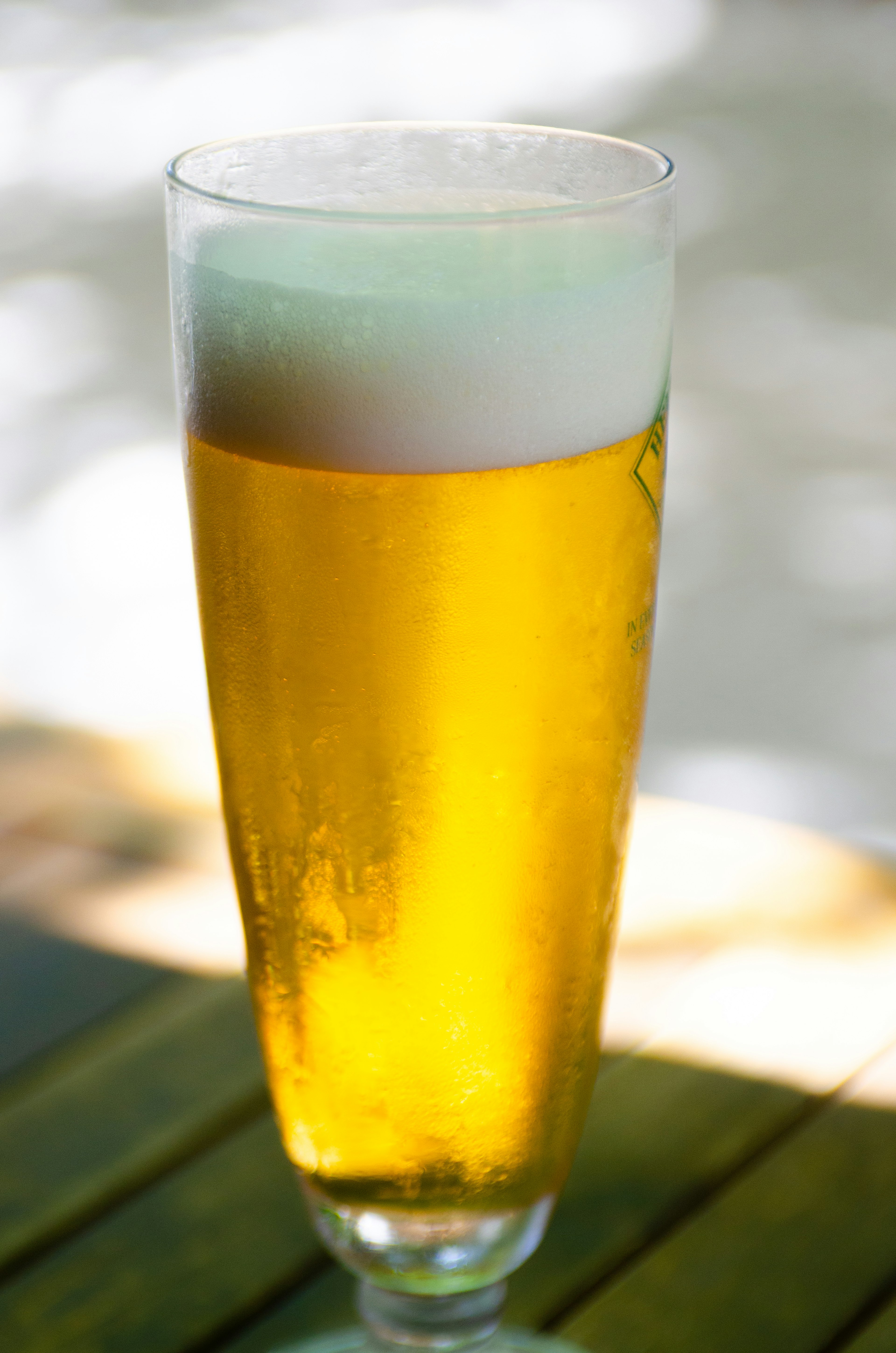 A clear glass filled with golden beer and foam