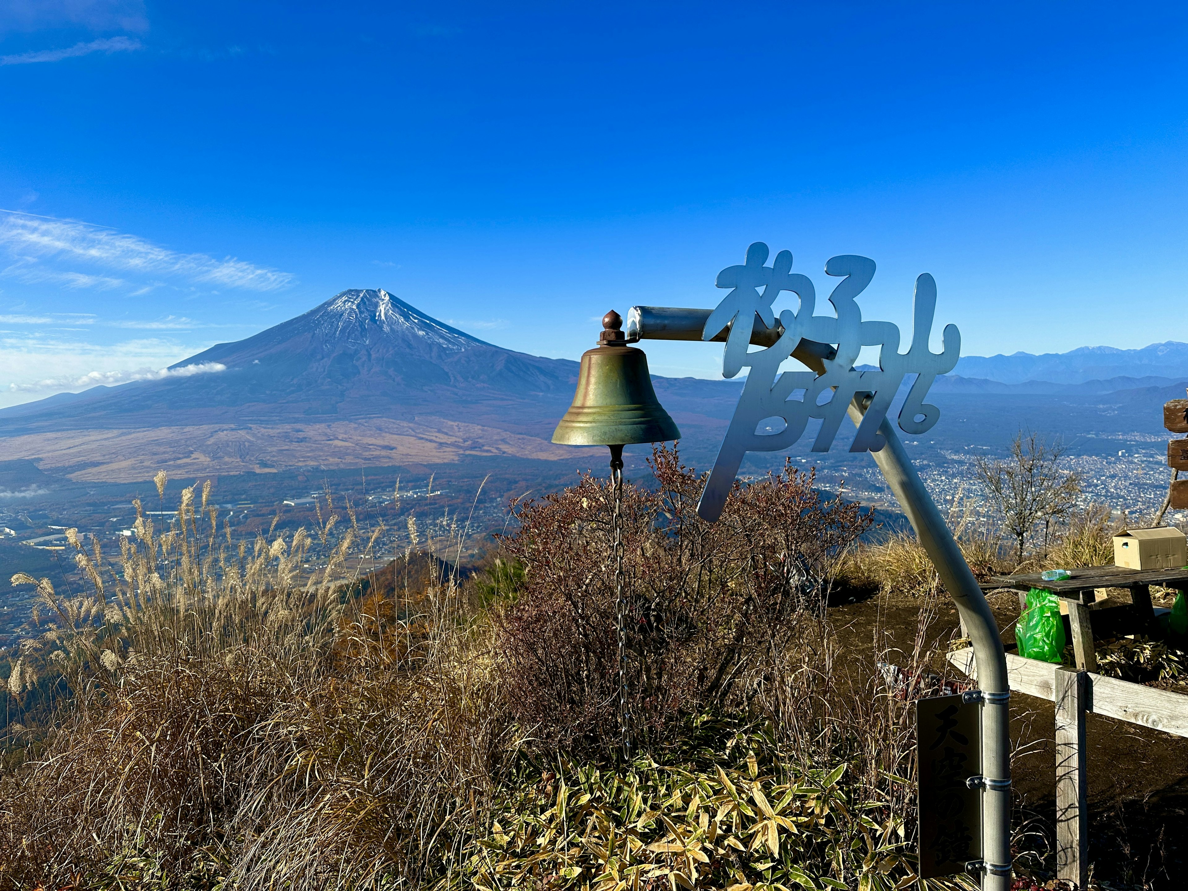 A bell and sign with Mount Fuji in the background