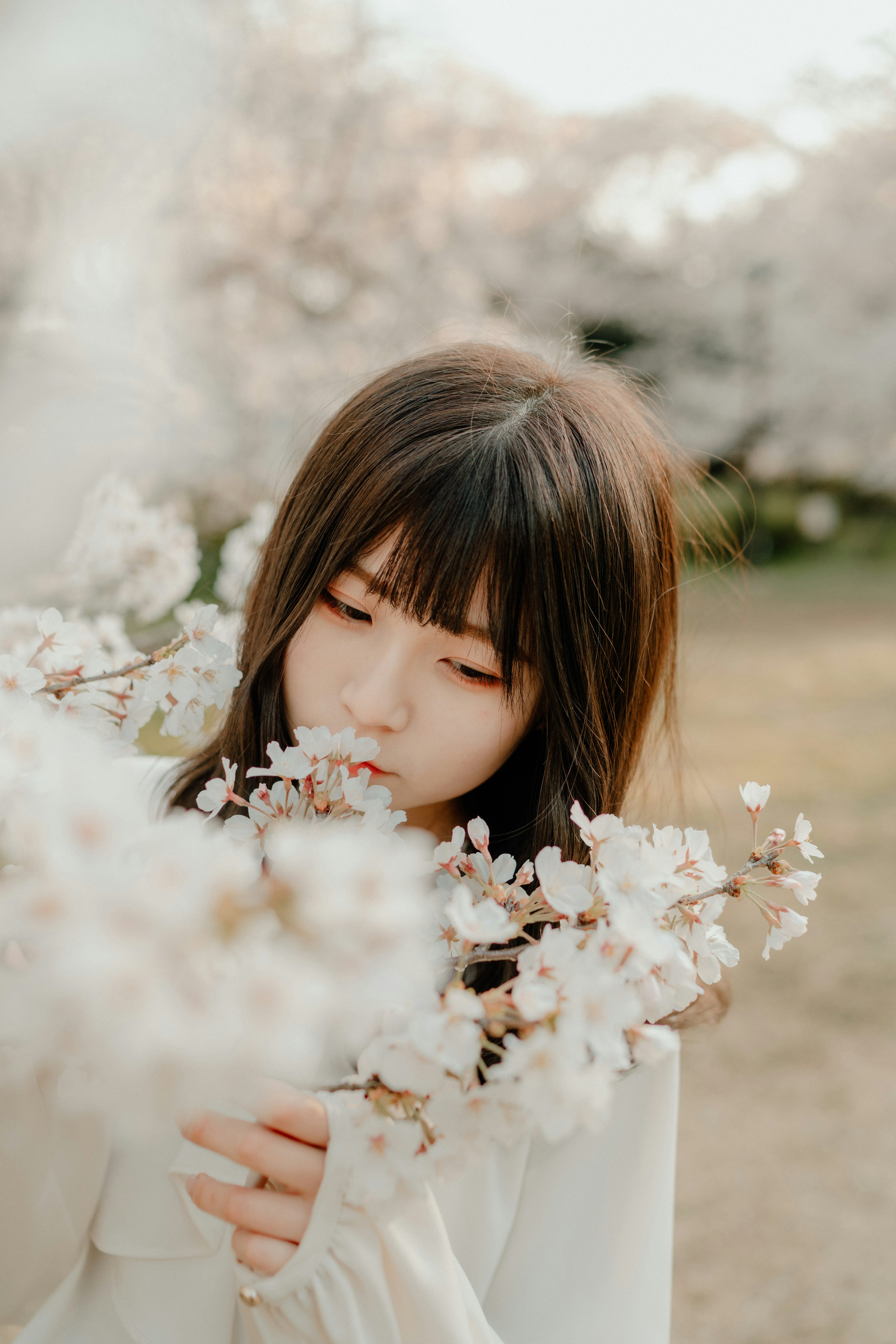 꽃에 둘러싸인 여성이 조용한 환경에서 부드럽게 미소짓고 있다