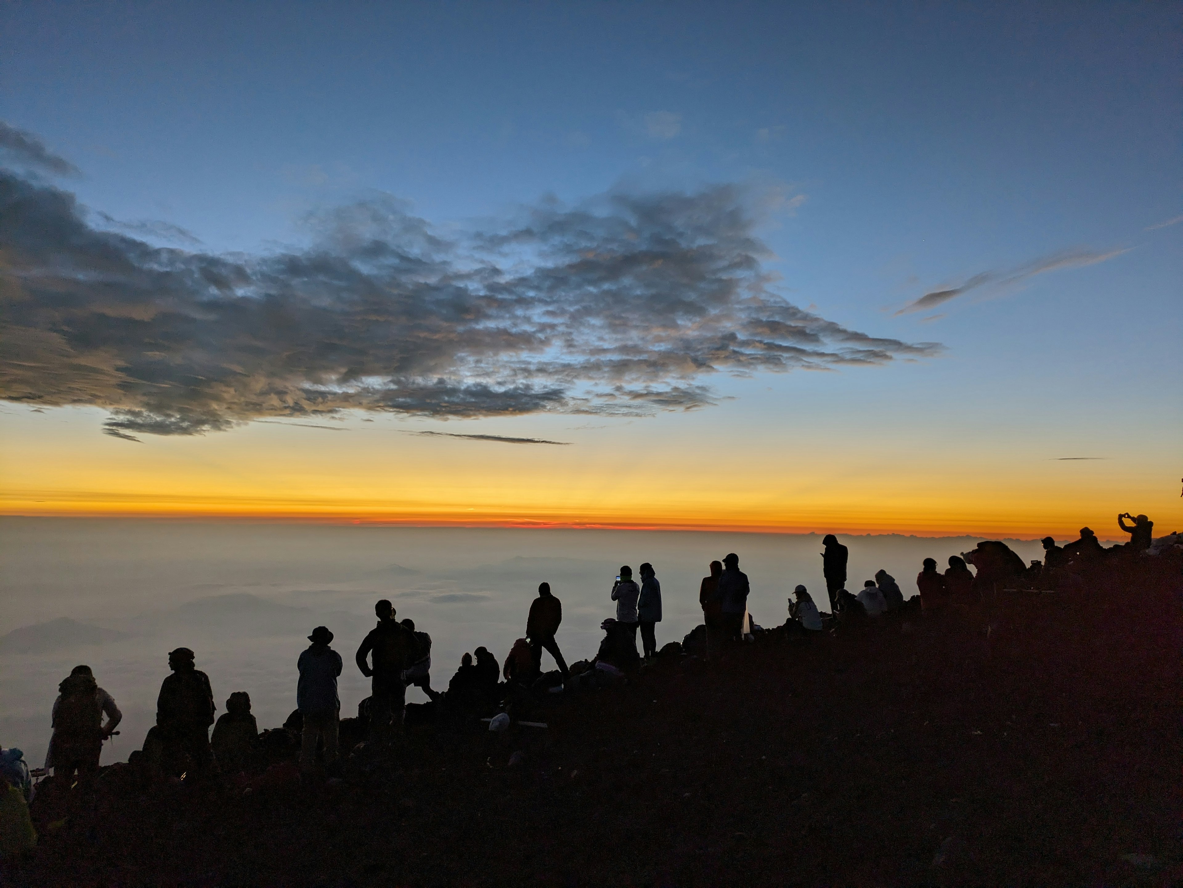 Silhouetten von Menschen, die den Sonnenaufgang mit einem schönen orangenen Himmel beobachten