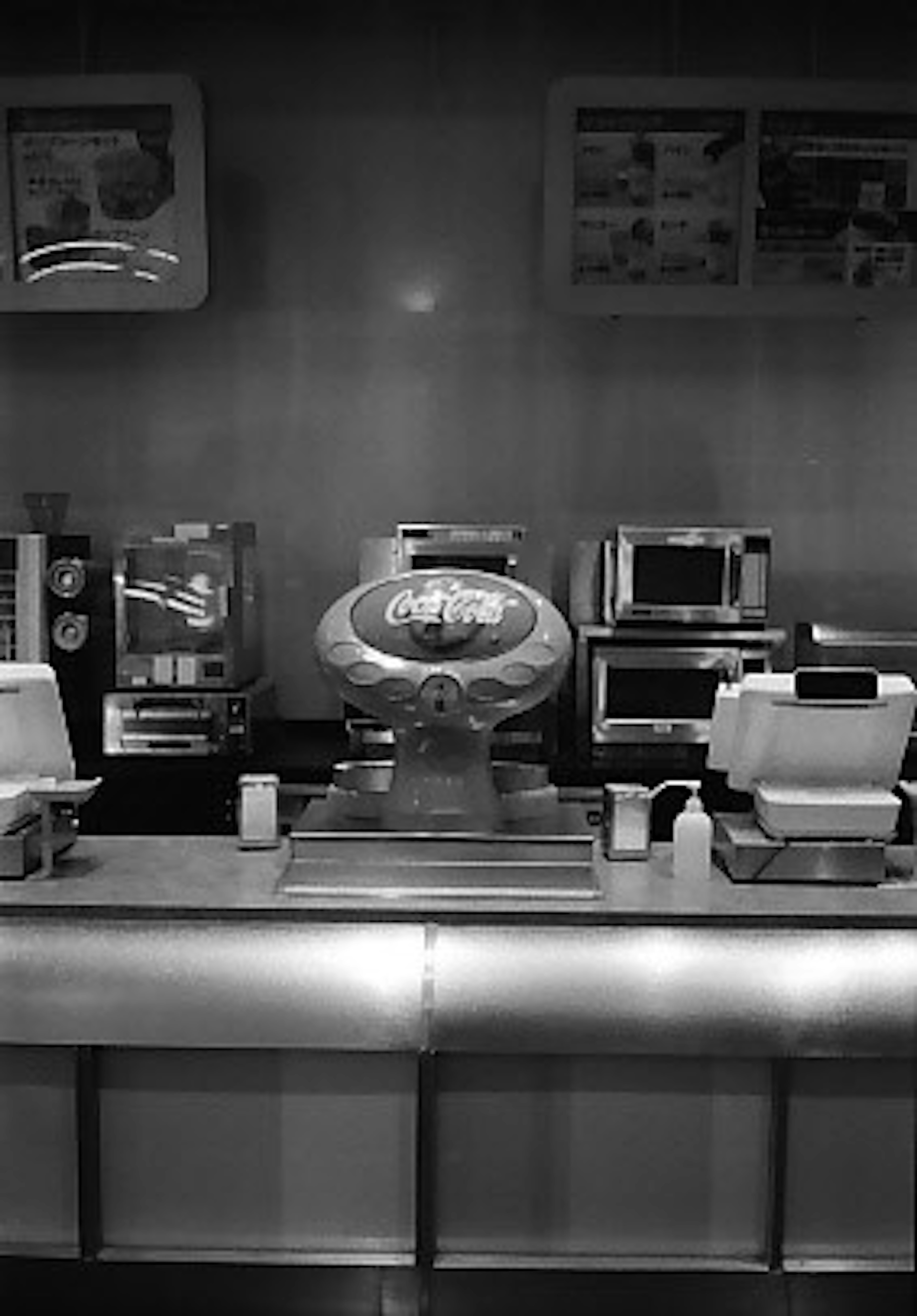 Black and white café counter with beverage dispenser and electronic equipment