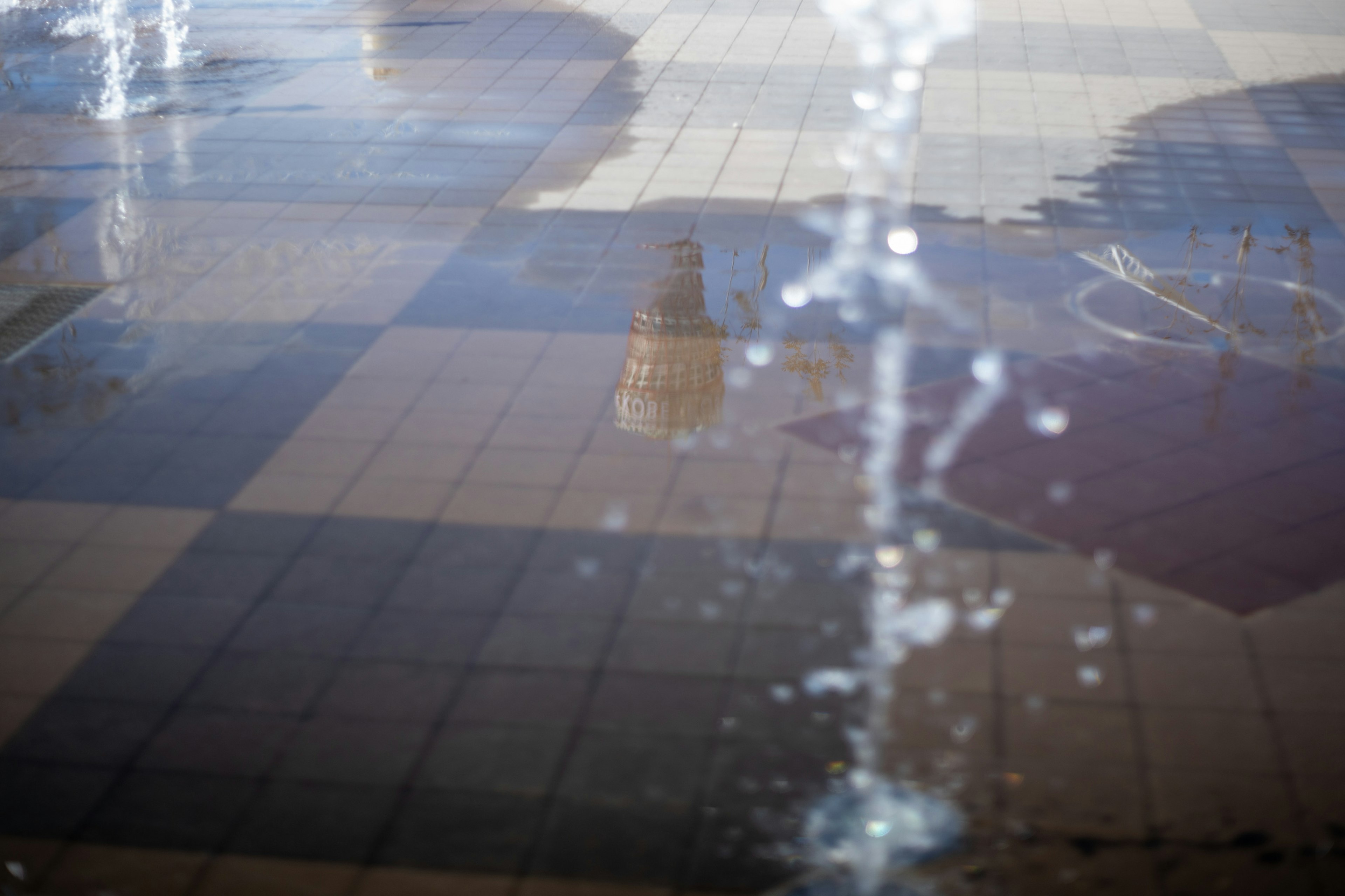 Riflesso di un edificio e motivo di piastrelle nell'acqua