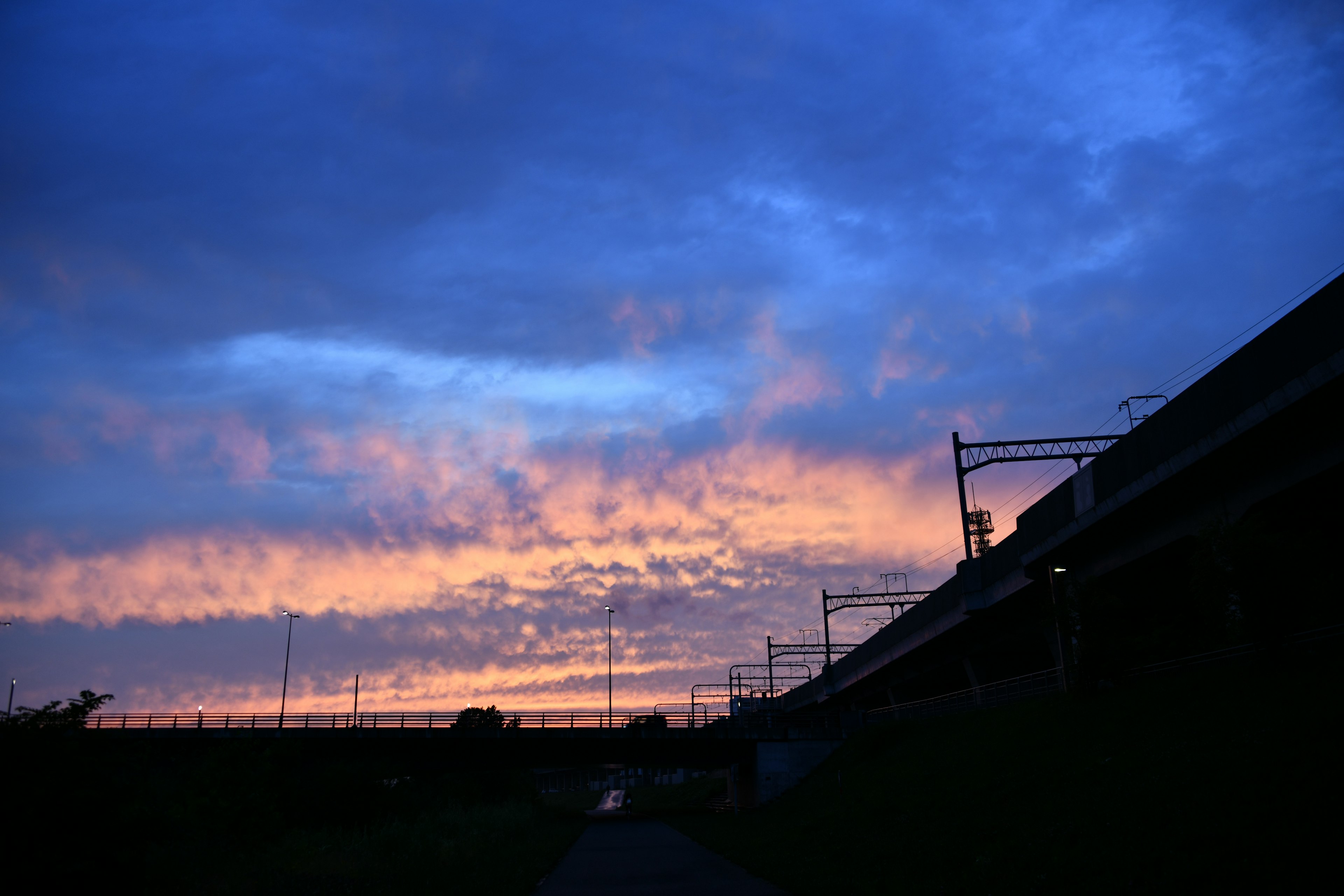 Cielo al tramonto con silhouette di binari e nuvole