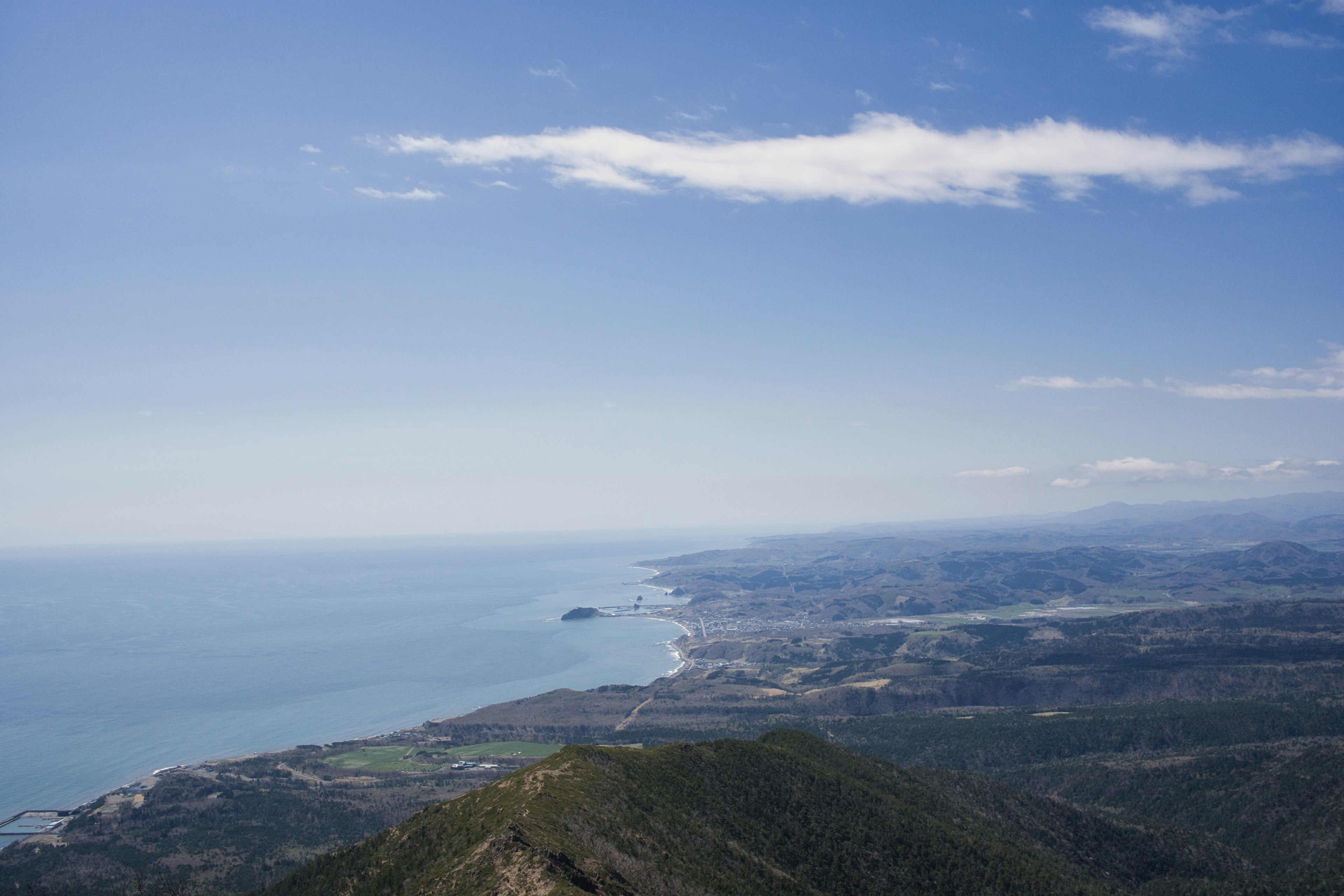 Vista escénica desde la cima de la montaña con costa y cielo azul