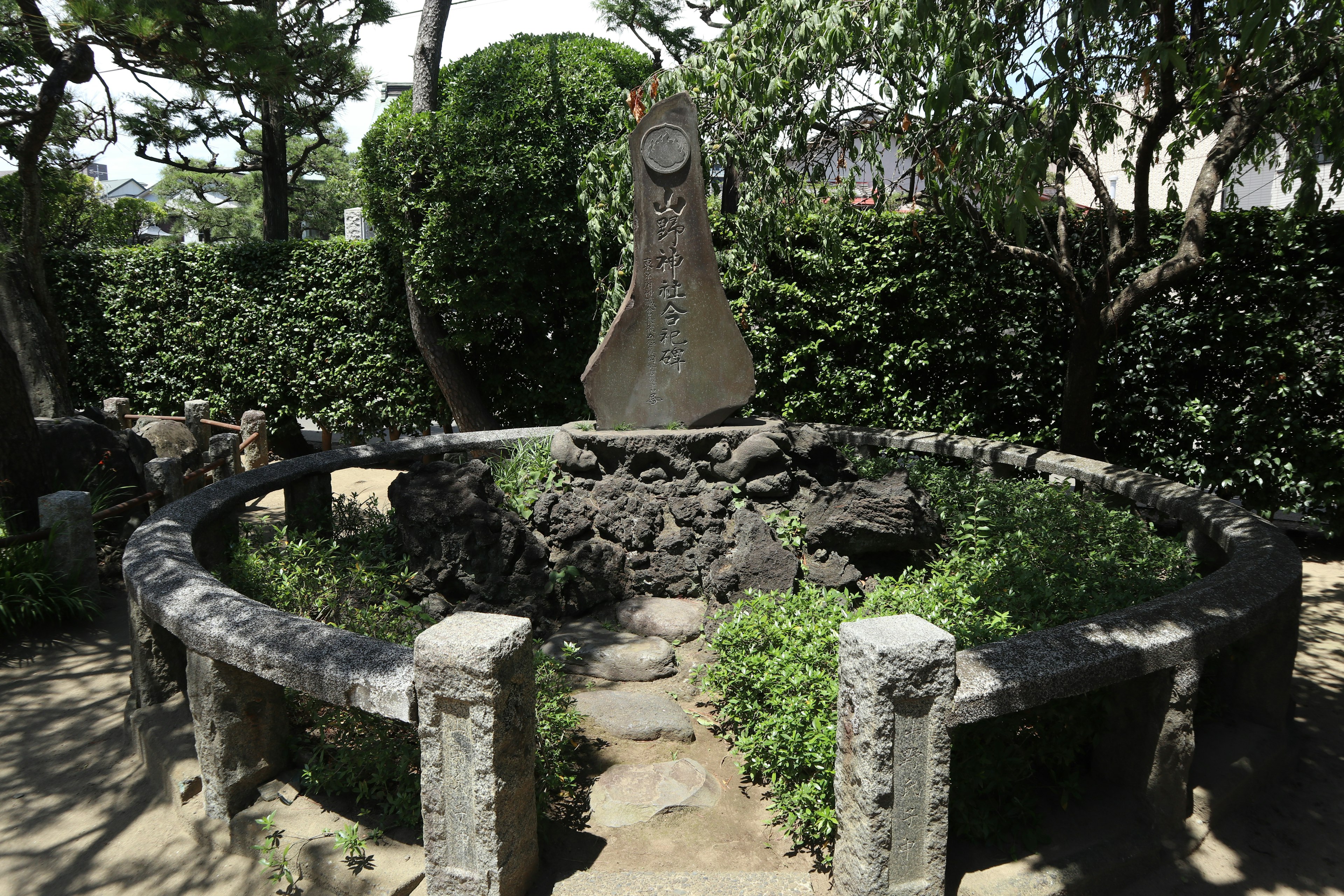 Stone monument surrounded by a circular stone arrangement in a garden